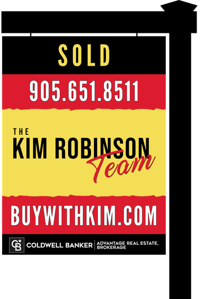 A prominently displayed red and yellow real estate sign from The Kim Robinson Team, standing tall with 'SOLD' proudly marked.