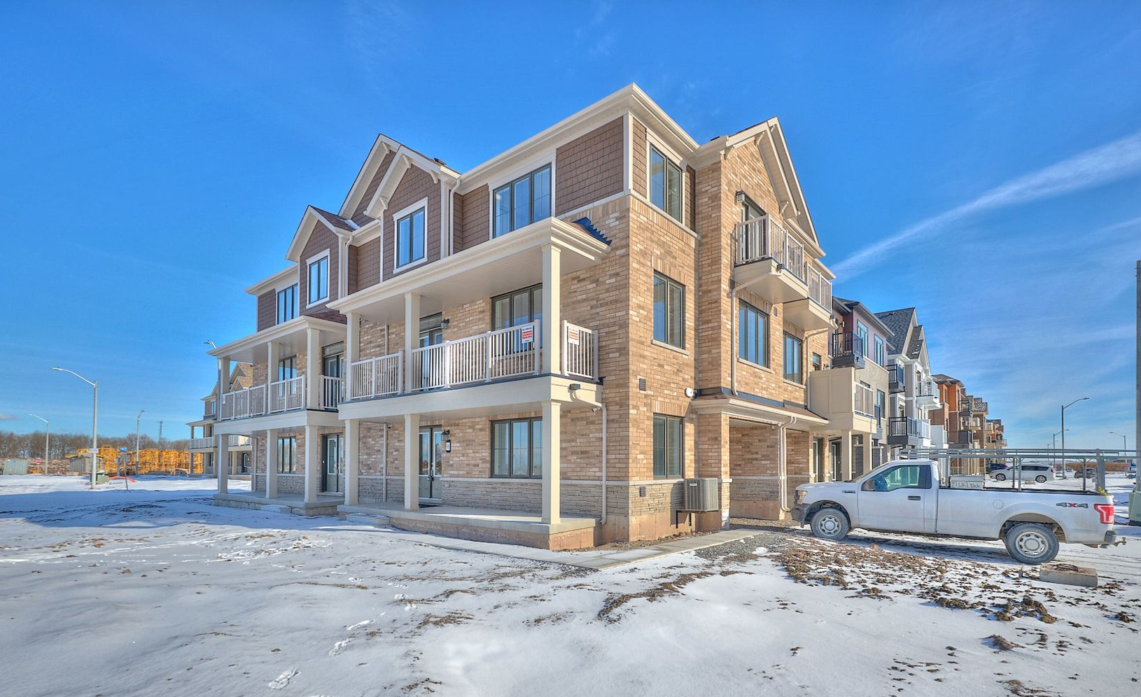 A three-storey townhouse with large patios in Welland, Ontario.