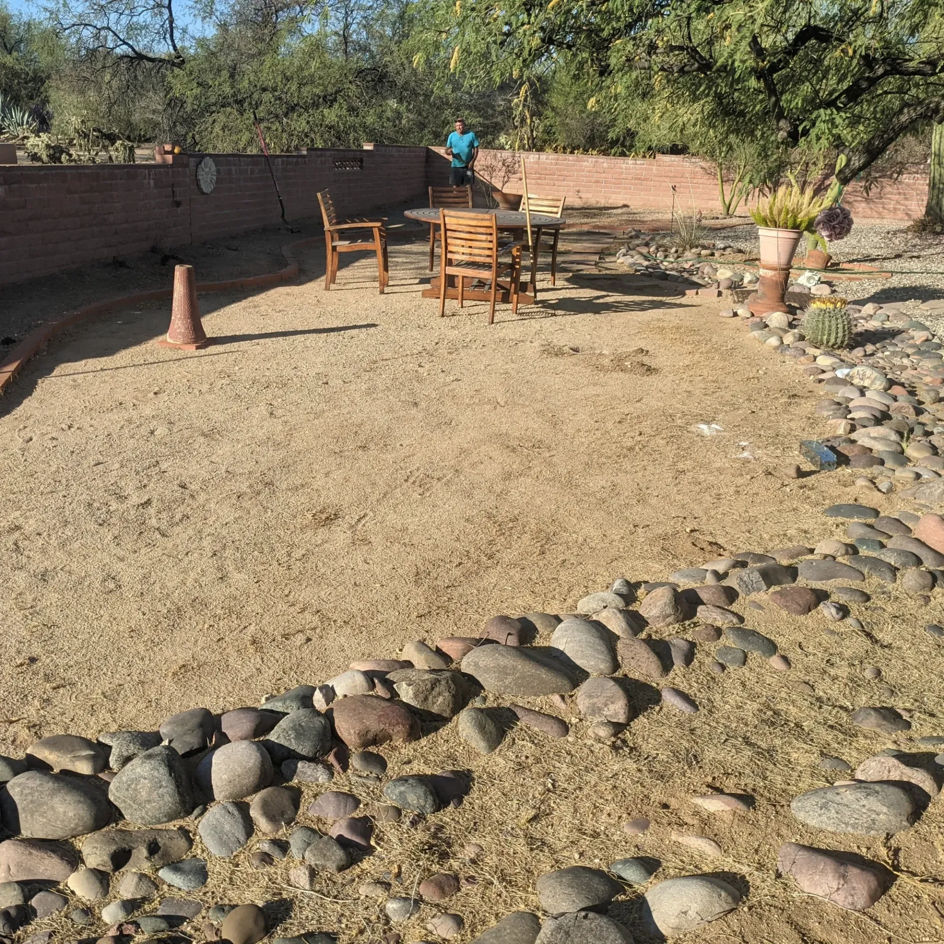 Aarons Repair and Remodel - A man is sitting at a table in a backyard surrounded by rocks.