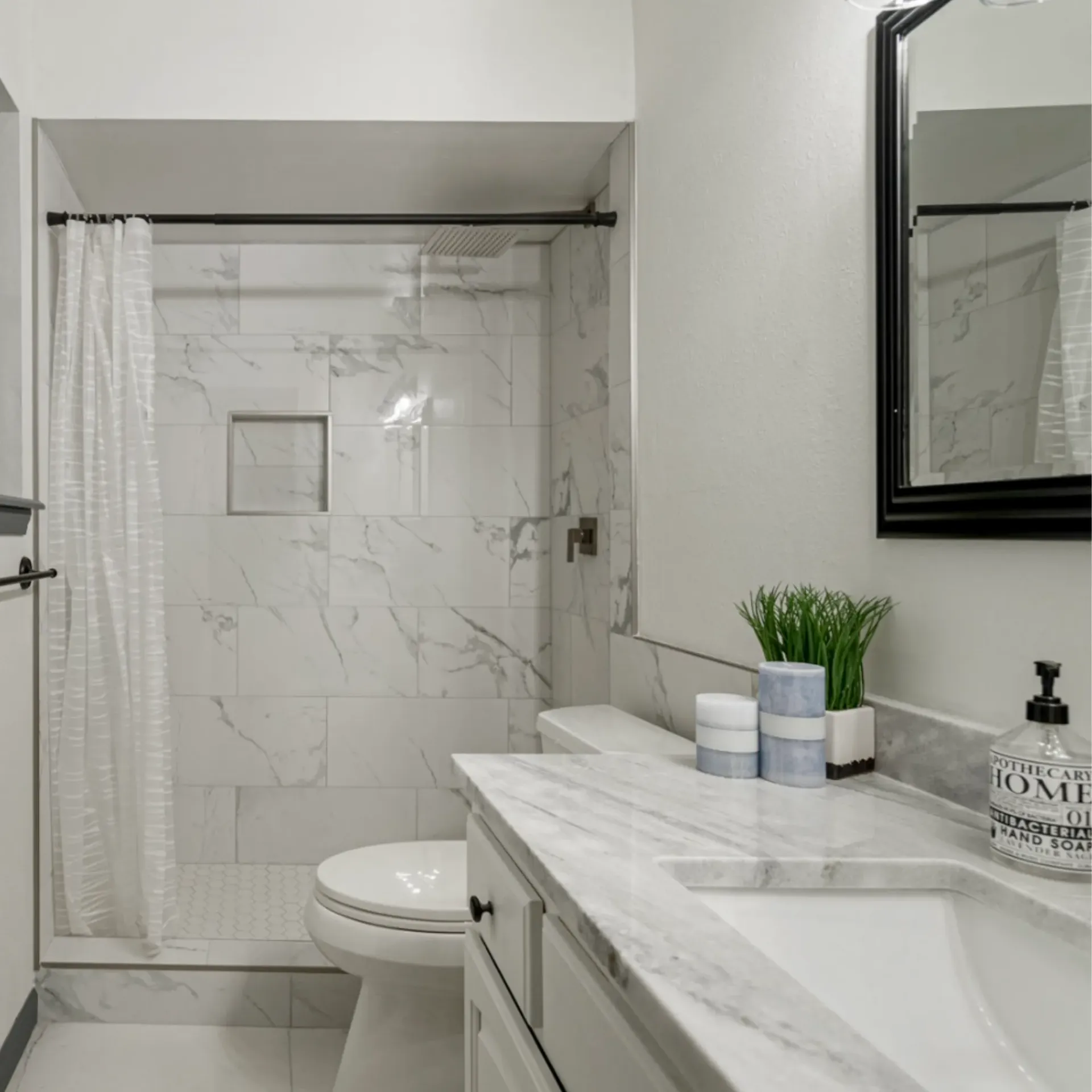 Aarons Repair and Remodel - A bathroom with a toilet , sink , mirror and shower.