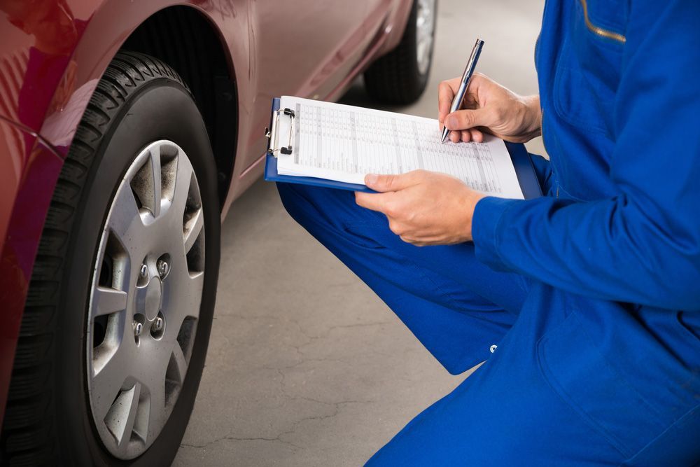 Young Mechanic with Clipboard Examining Car Wheel — East Coast Mechanic in Nambucca Heads, NSW