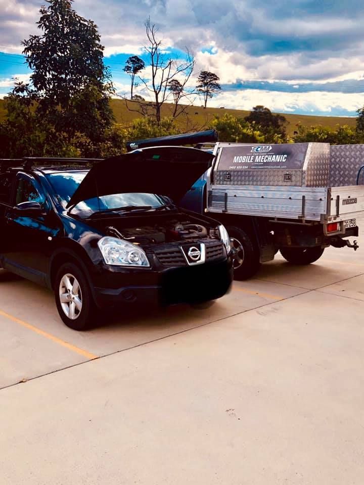 A Black Car With Its Hood Up is Parked Next to a White Truck — East Coast Mechanic in Nambucca Heads, NSW