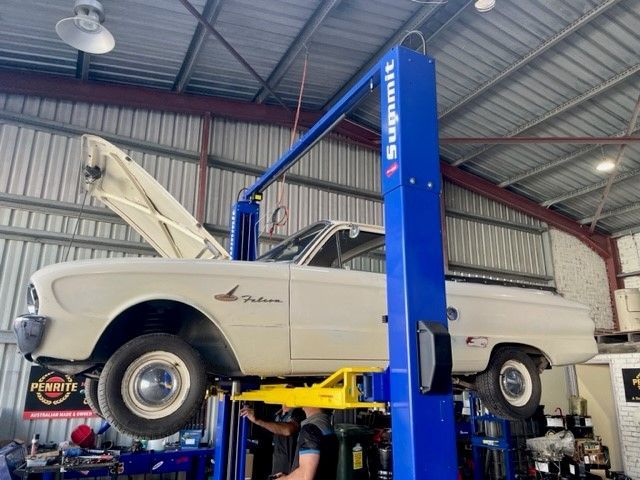 A White Truck is on a Lift in a Garage — East Coast Mechanic in Nambucca Heads, NSW