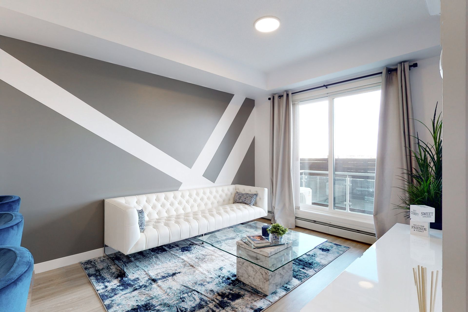 A living room with a white couch and a blue chair