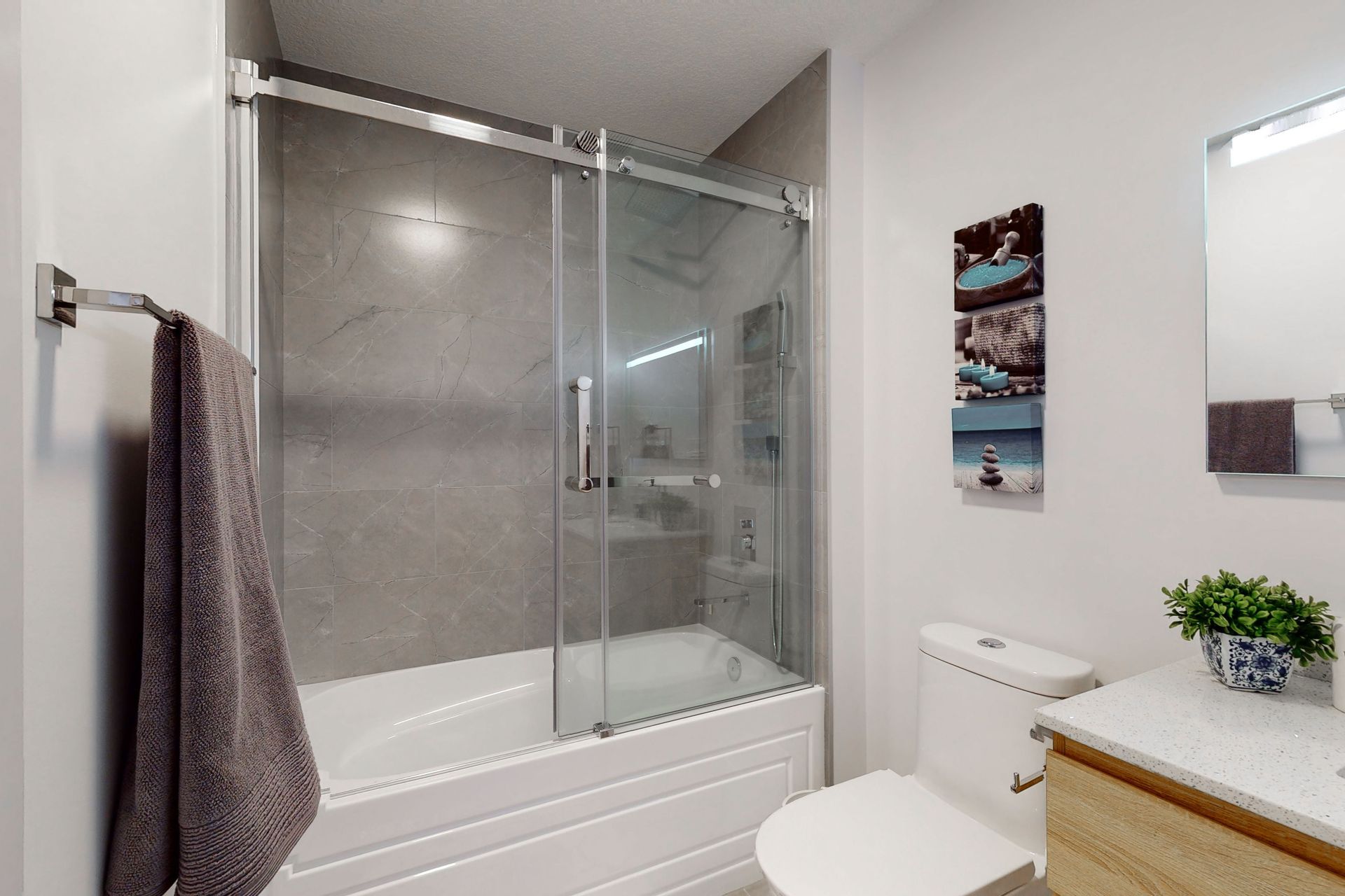 A bathroom with a tub , toilet , sink and mirror.
