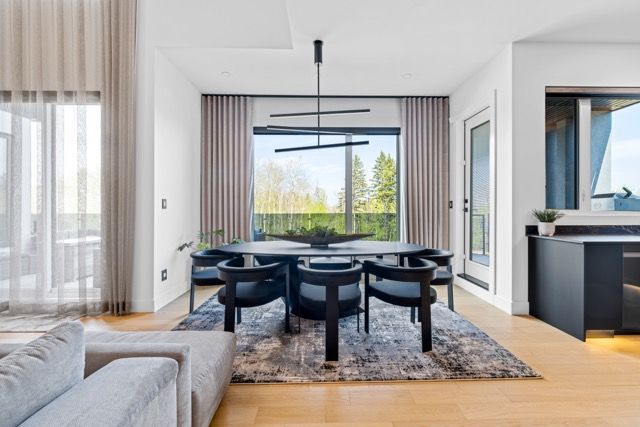 A dining room with a table and chairs and a large window.