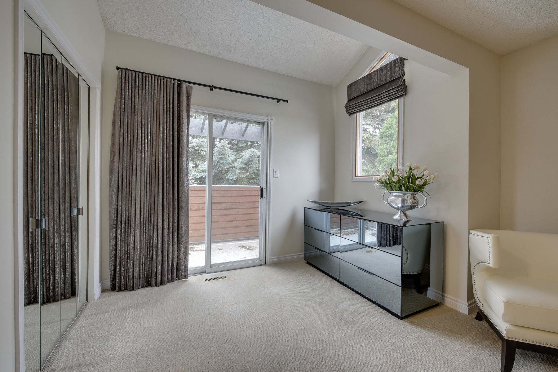 A living room with a sliding glass door and a dresser.