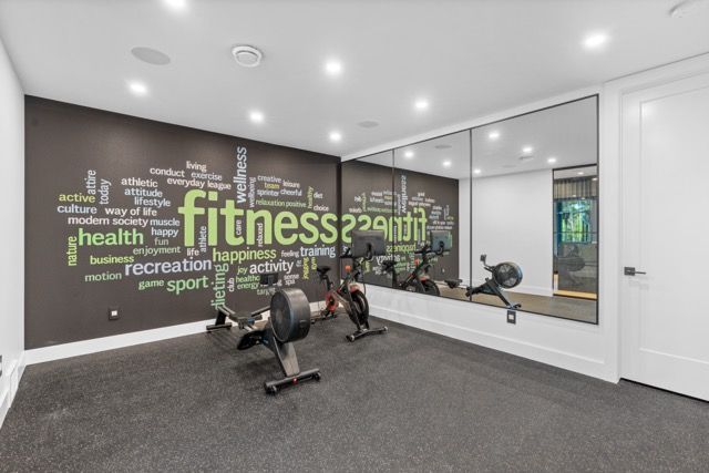 A gym with a large mirror and a wall that says fitness.