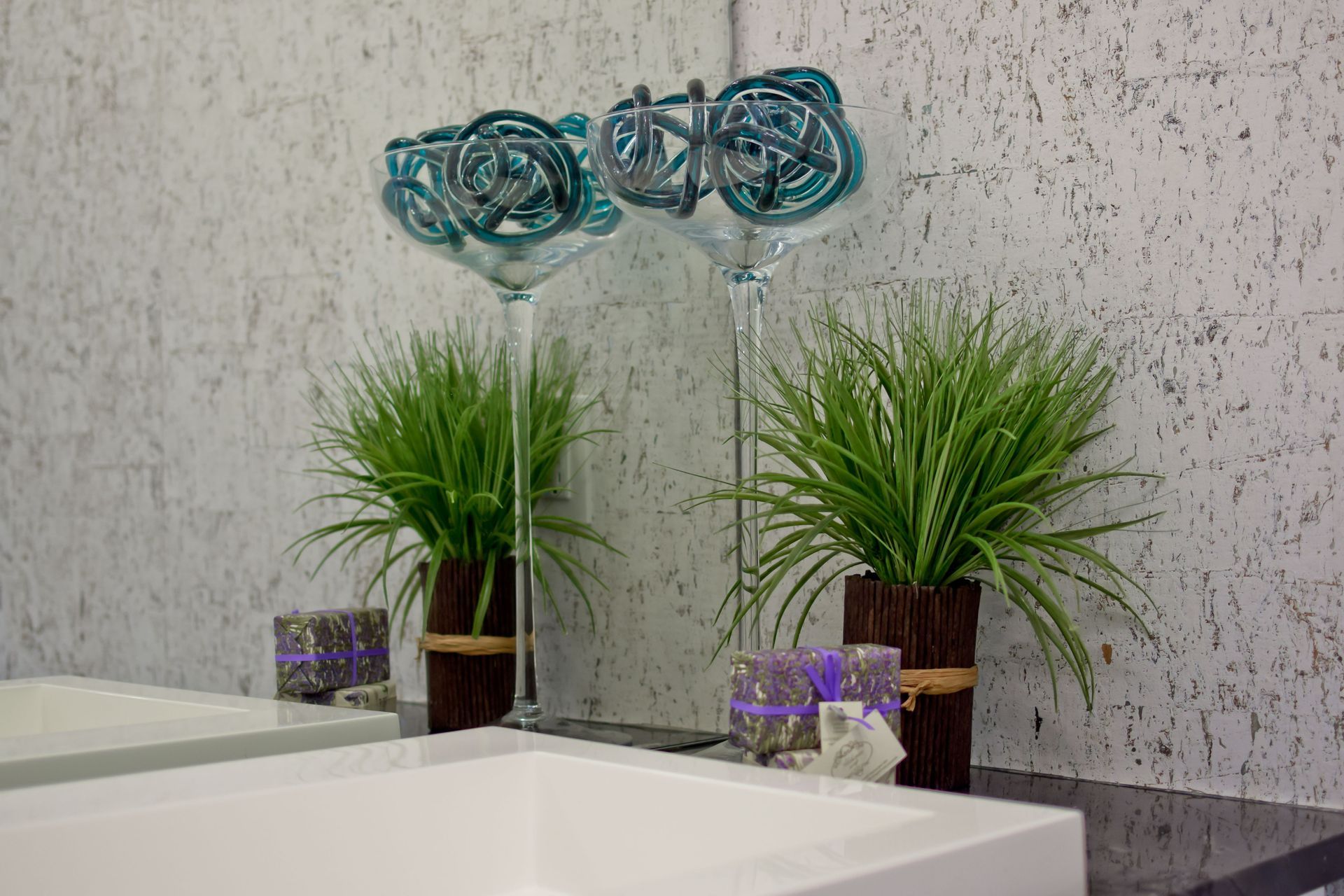 A bathroom with a sink , mirror , plants and candles