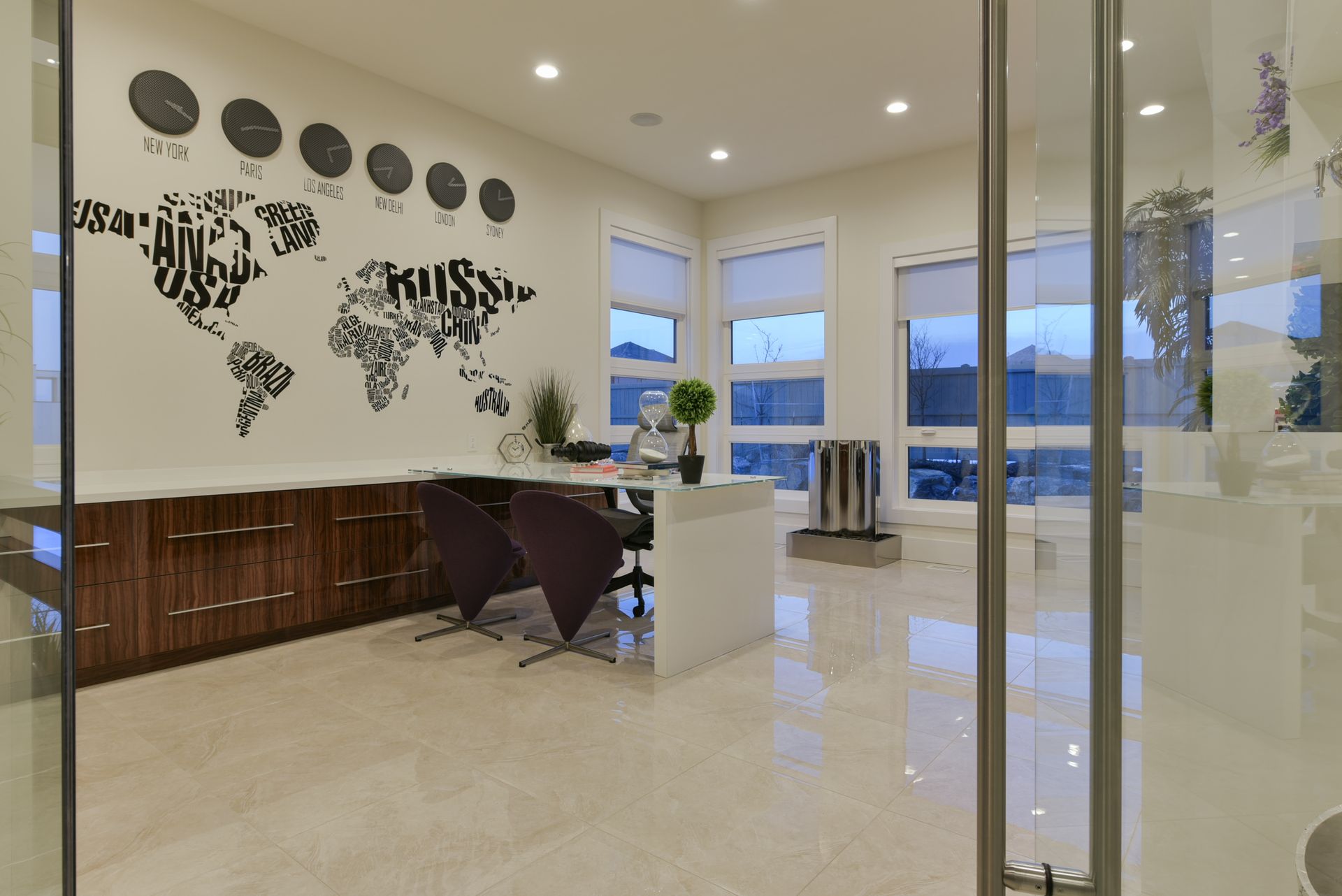 A room with a desk and chairs and a map of the world on the wall.
