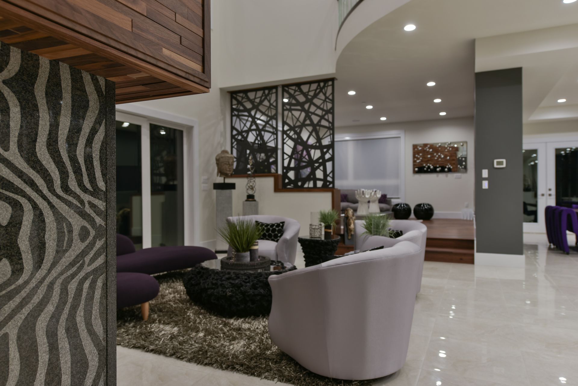 A living room with purple chairs and a zebra print wall