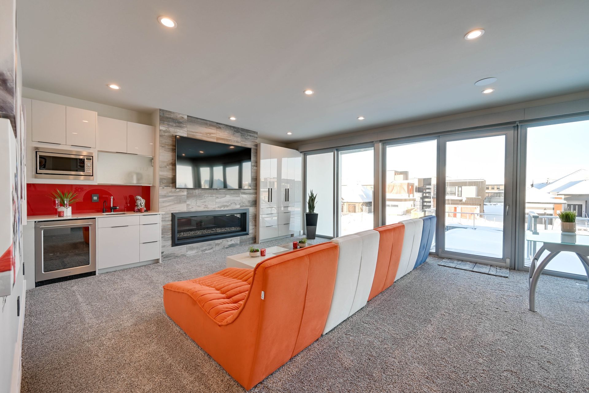 A living room with a couch , fireplace , and sliding glass doors.