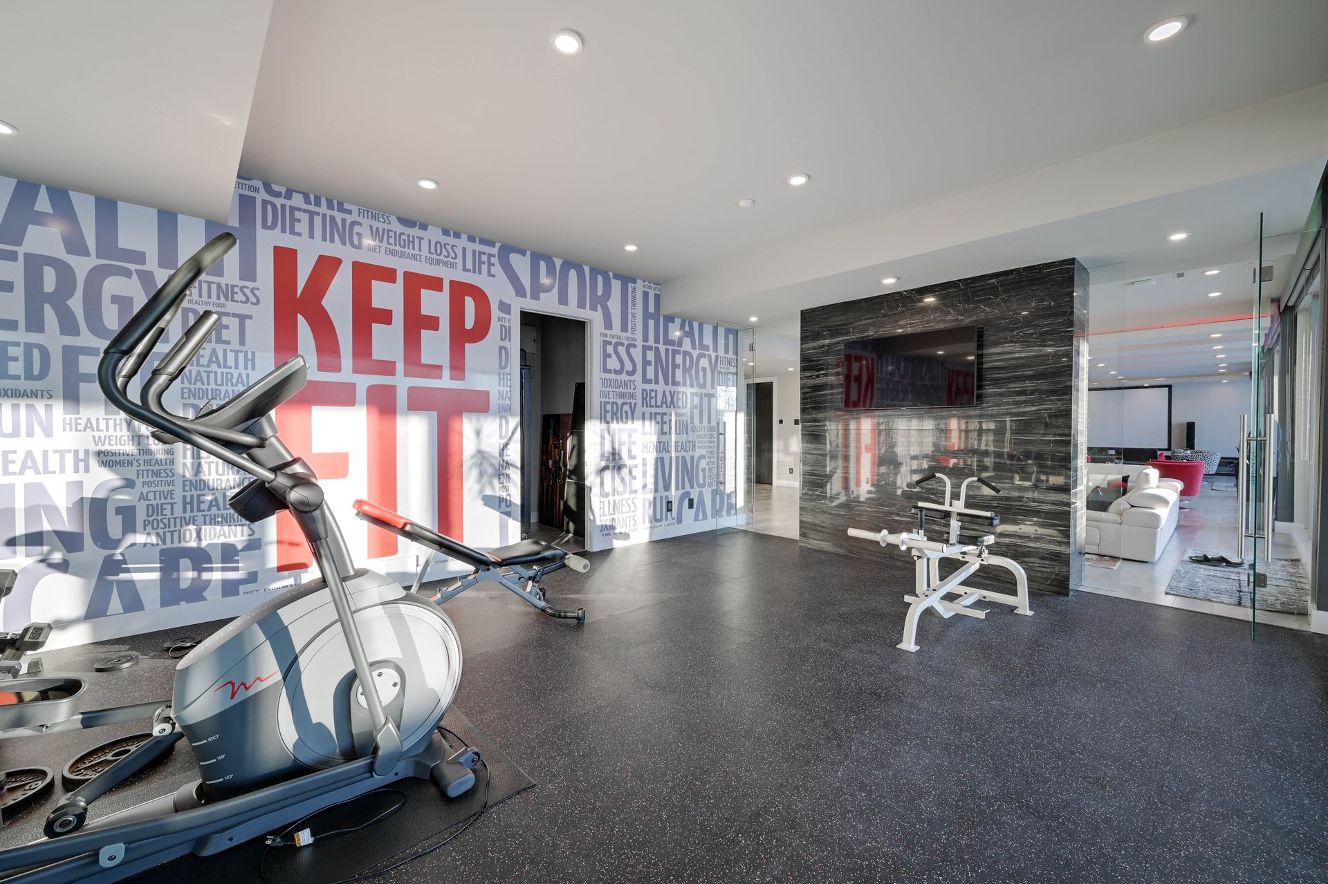 A gym with a wall that says keep fit on it