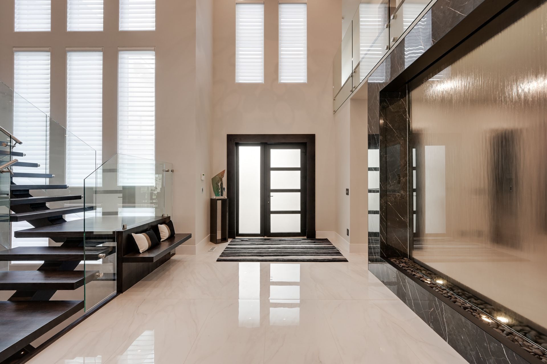 A large hallway with a staircase and a fireplace
