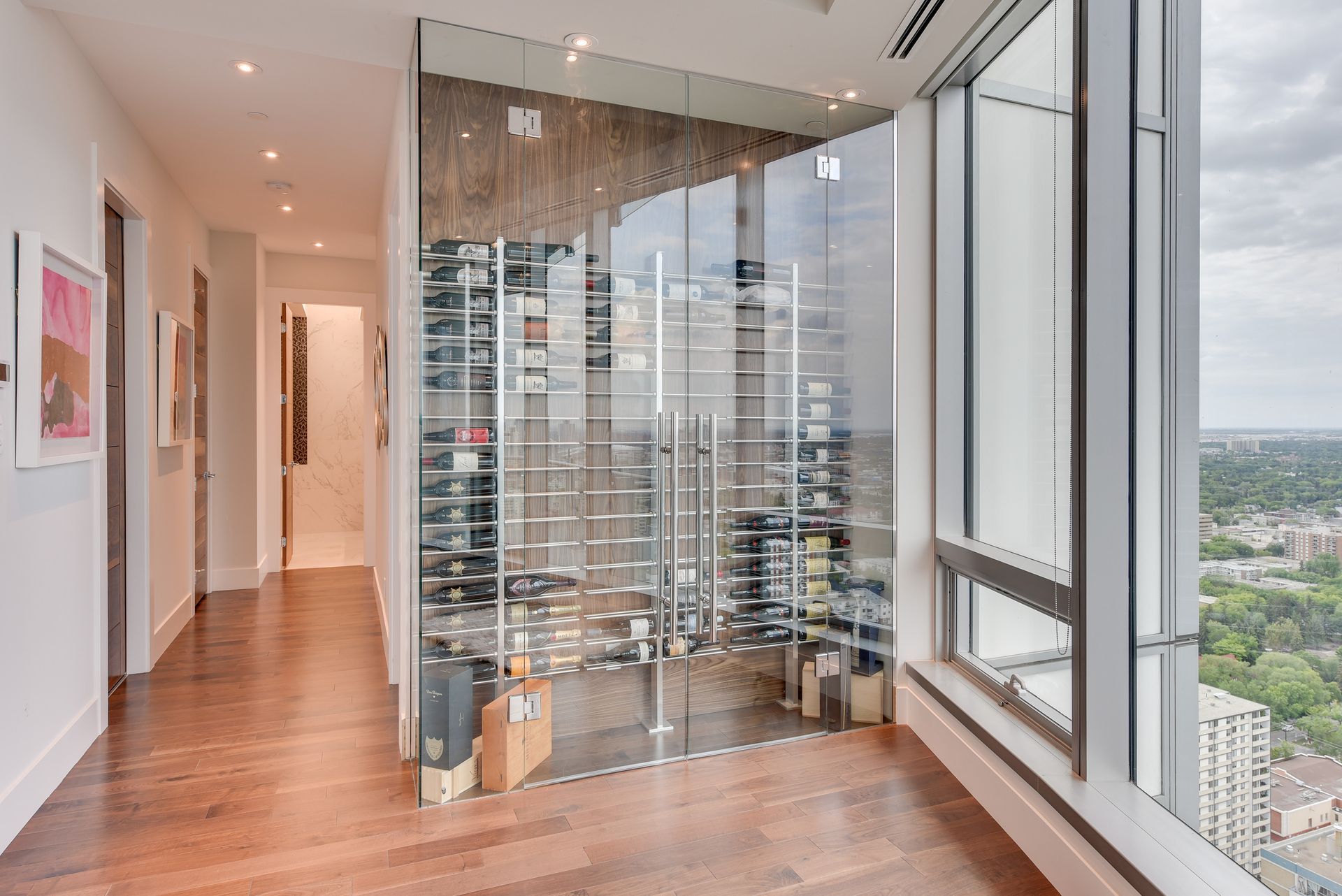 There is a wine cellar in the middle of the room with a view of the city.