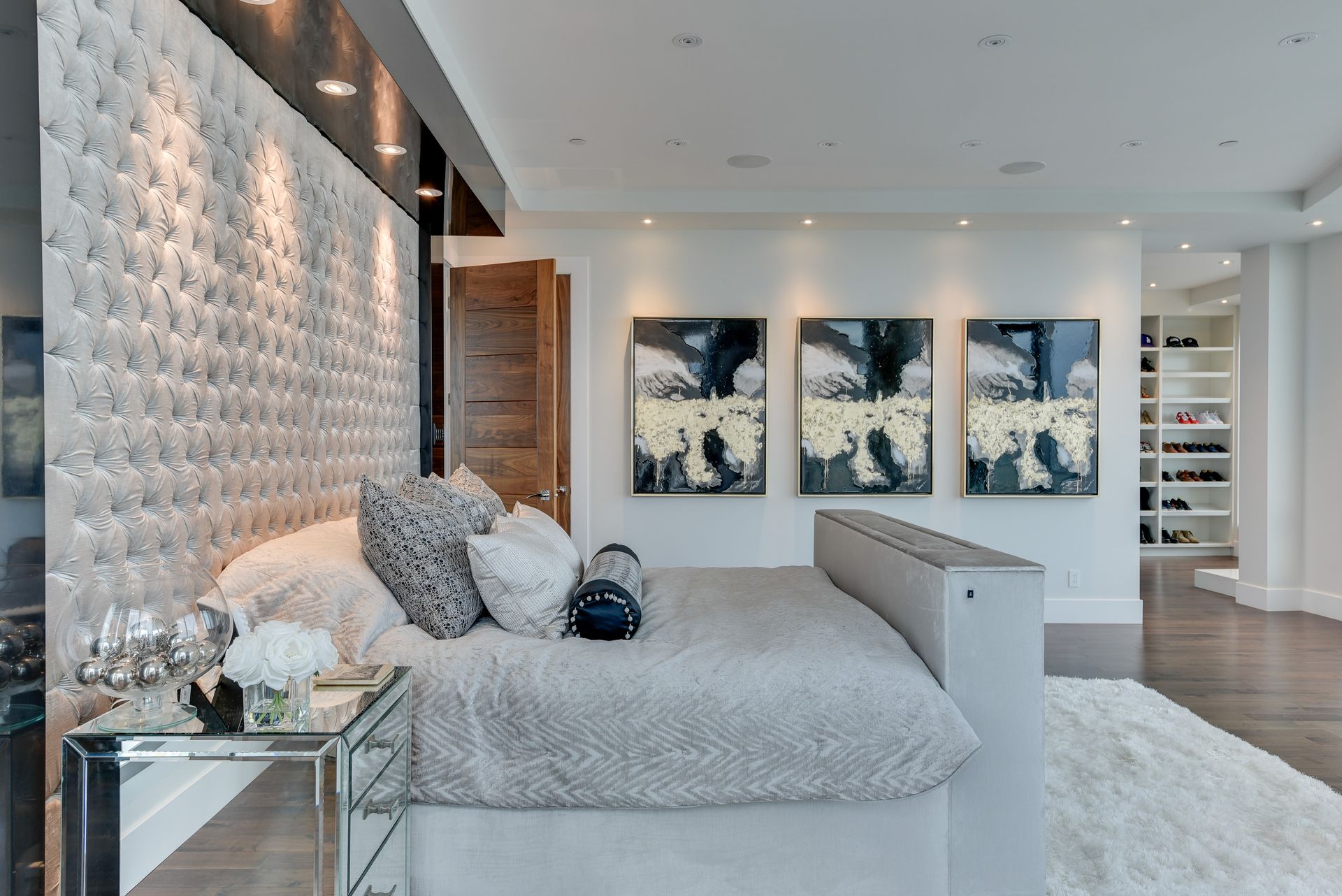 A bedroom with a bed and three paintings on the wall