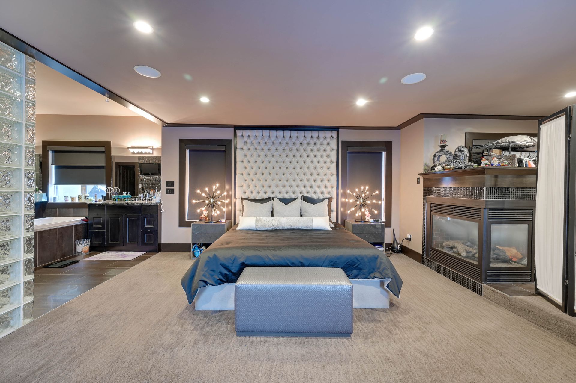 A bedroom with a large bed and a fireplace