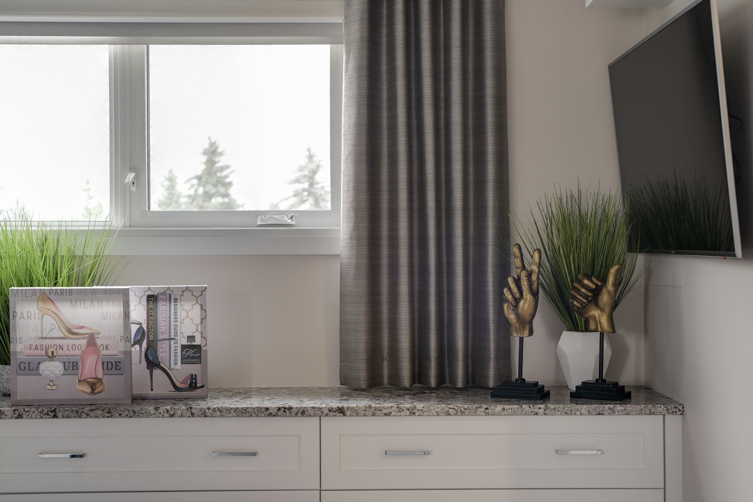 A bedroom with a dresser , a television , and a window.