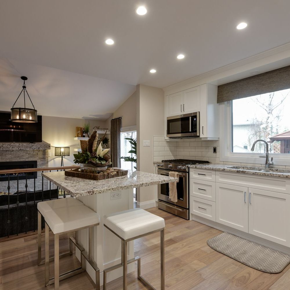 A kitchen with white cabinets and granite counter tops