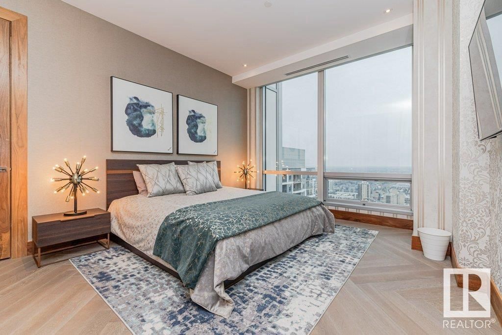 A bedroom with a large bed and a large window.
