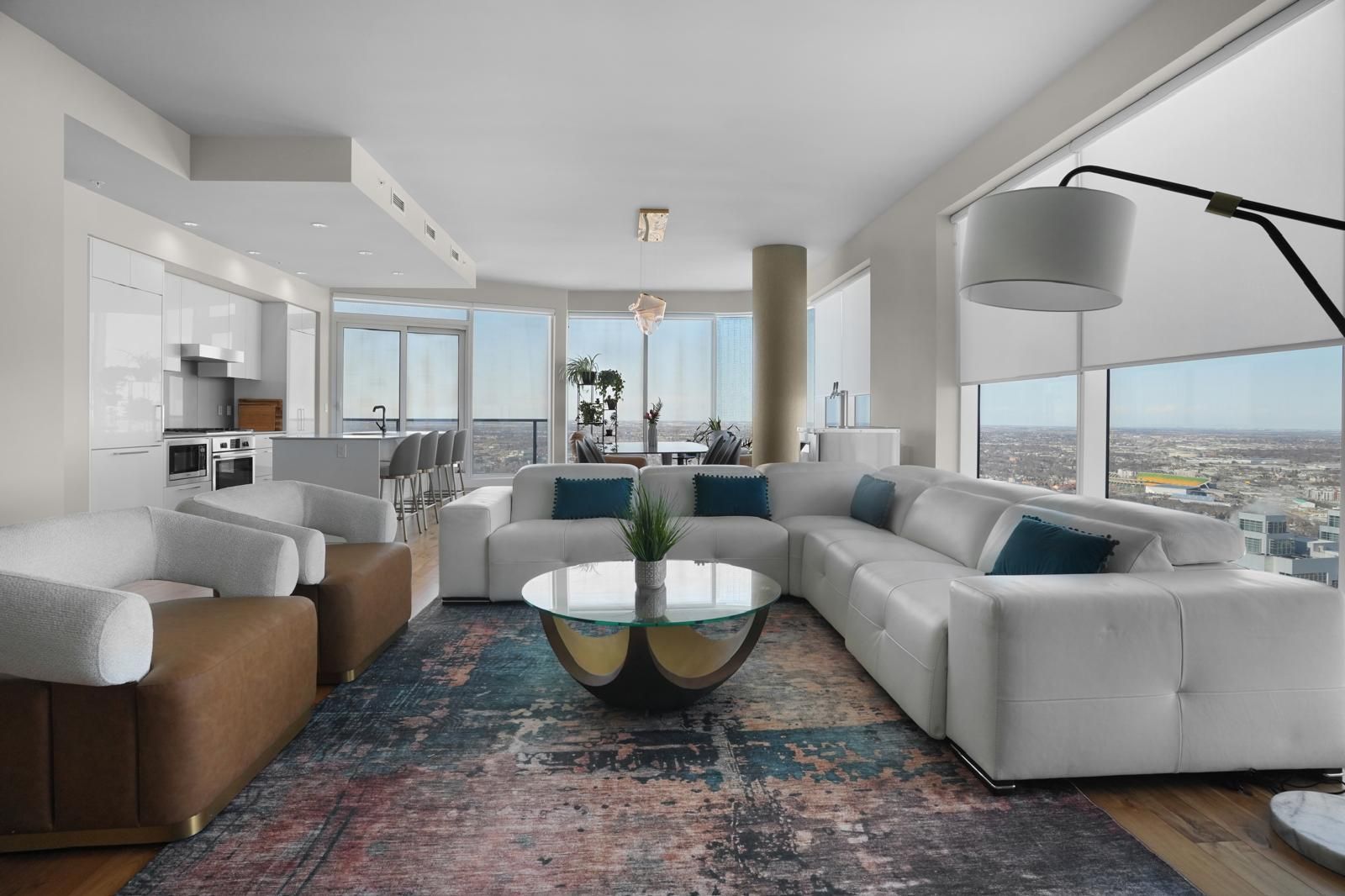A living room with a large couch , chairs , and a coffee table.