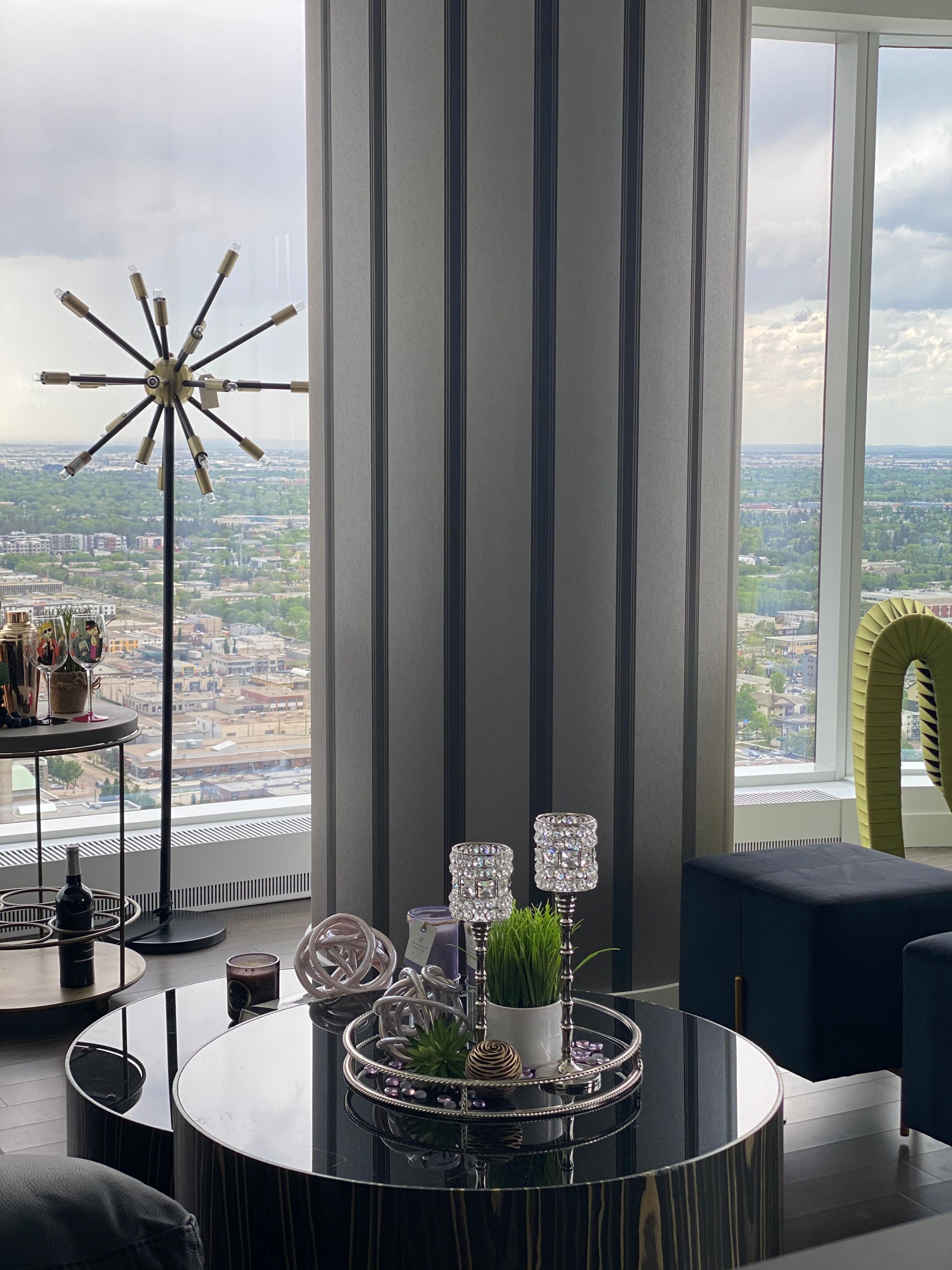 A living room with a round coffee table and a large window