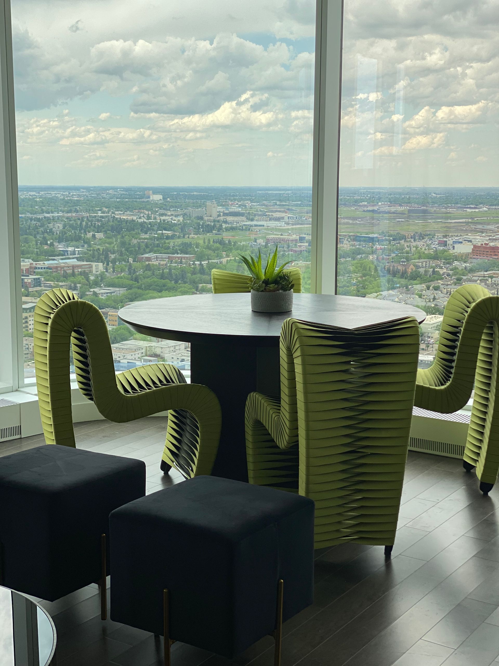 A table and chairs in a room with a view of a city.