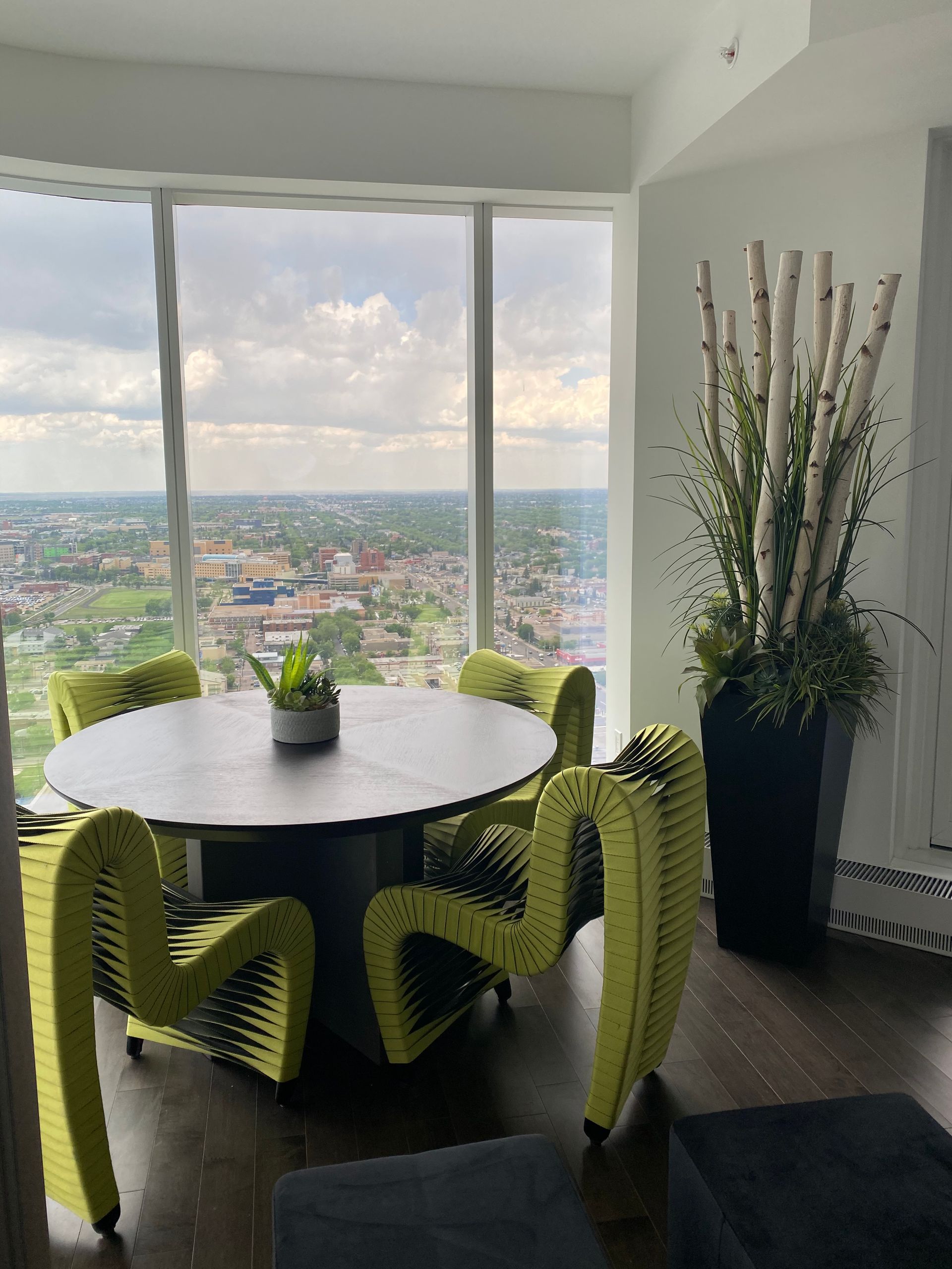 A dining room with a table and chairs and a large window