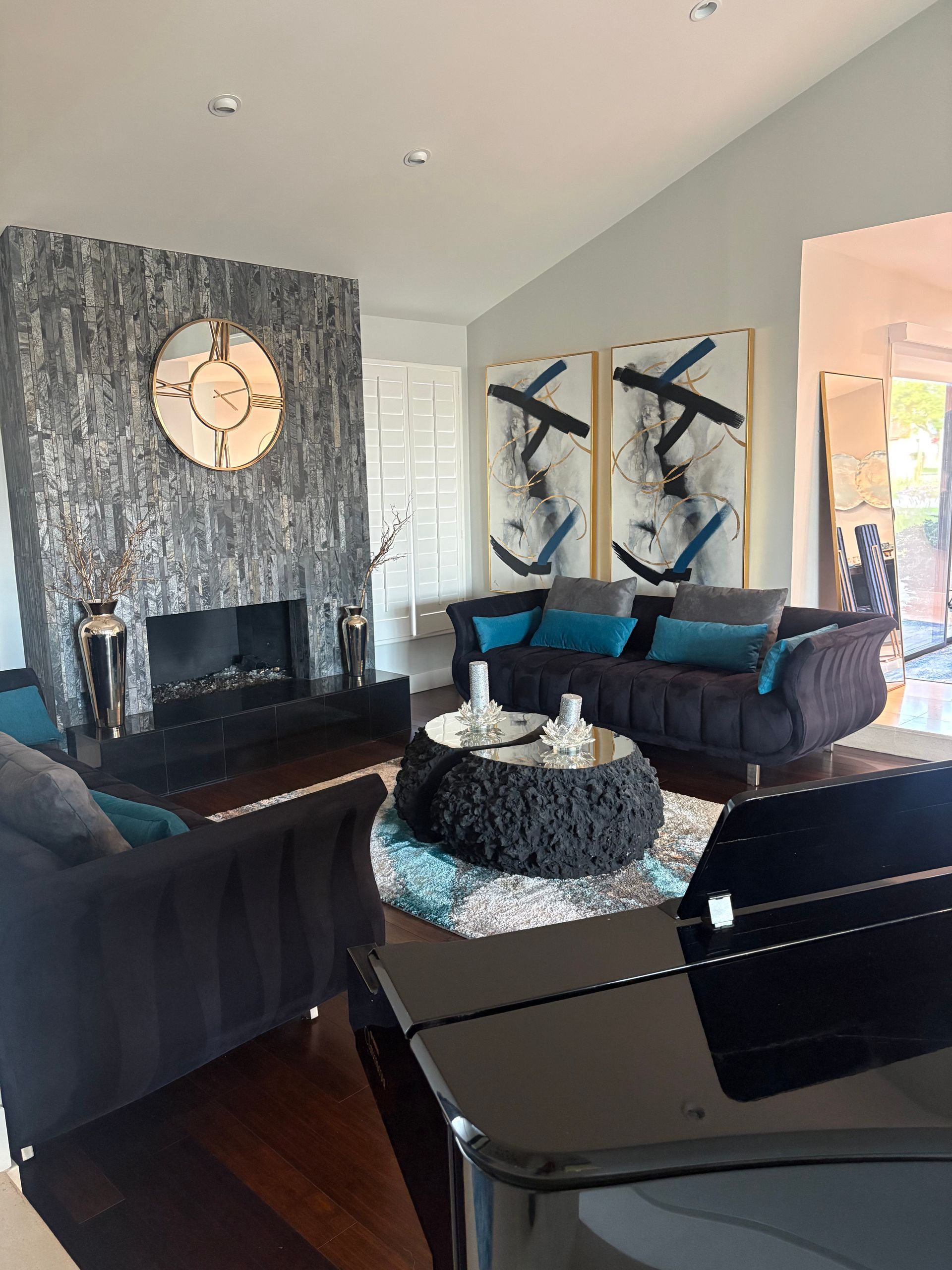Living room with fireplace, blue and black decor, and a grand piano.