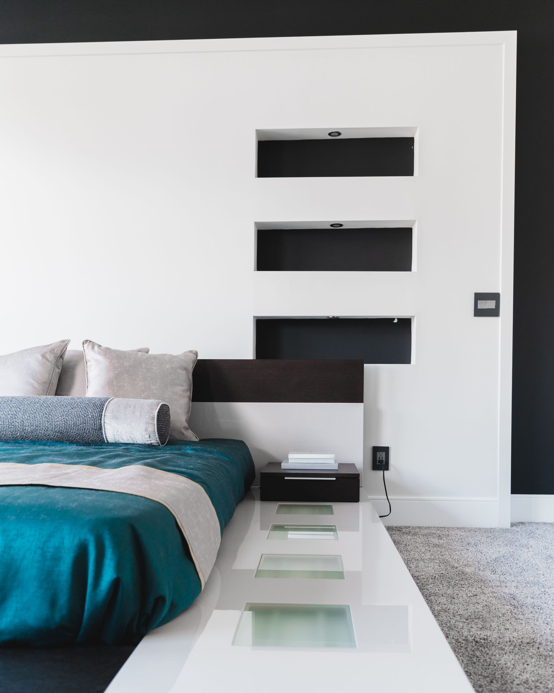 A bedroom with a blue bed and white walls
