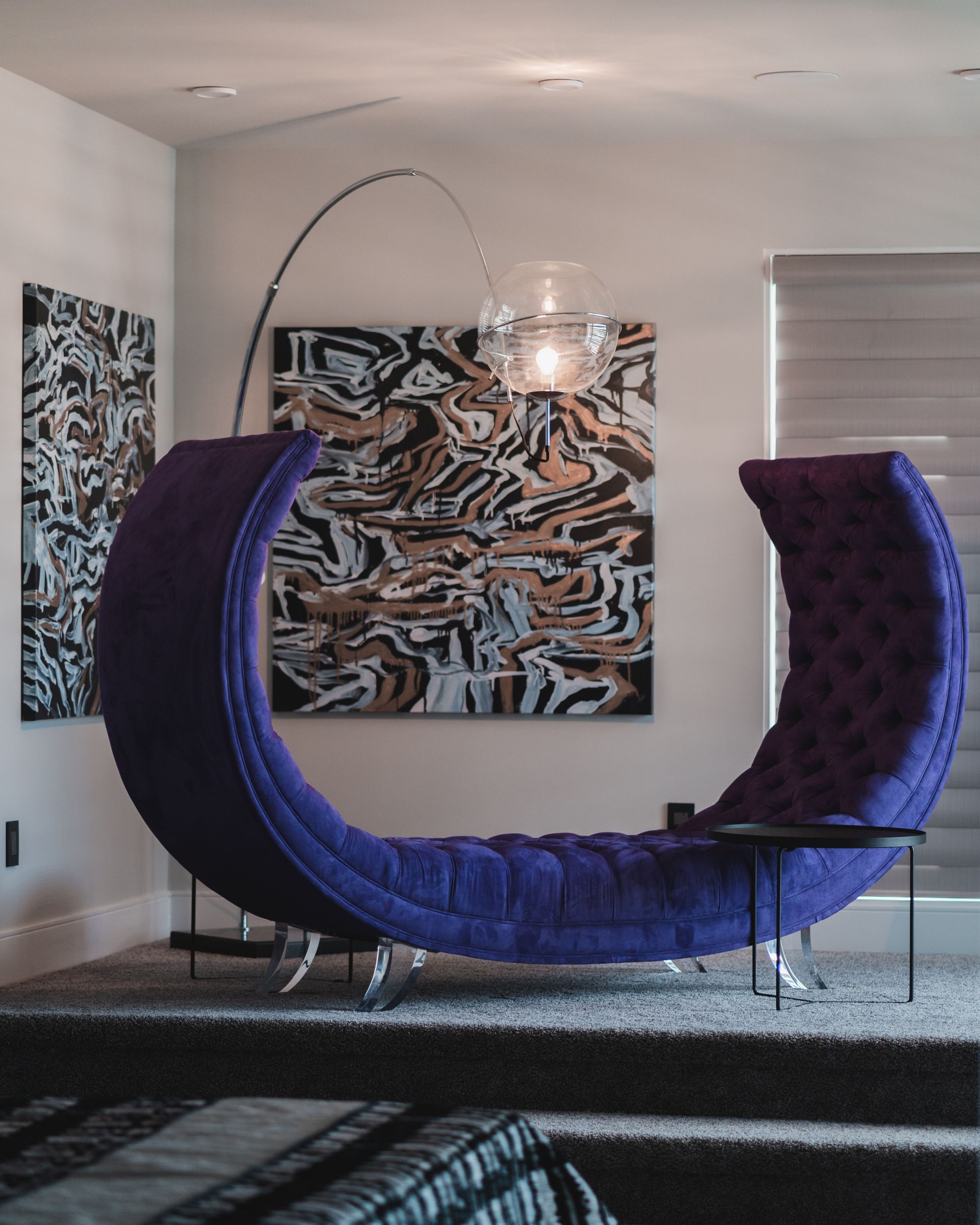 A living room with a purple chair and a lamp