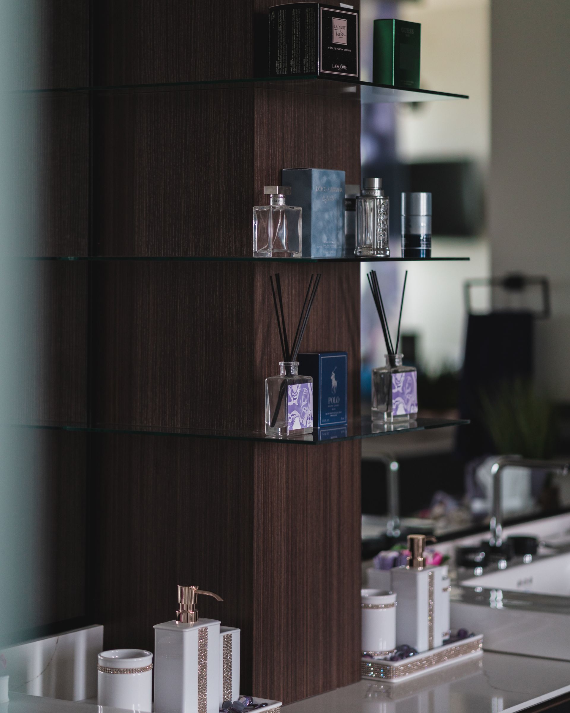 A bathroom with a shelf filled with bottles and a sink.