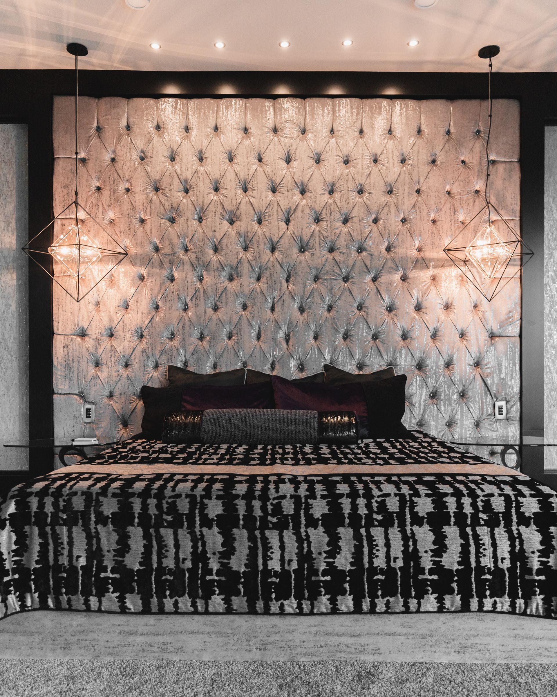 A bedroom with a large bed and a tufted headboard.