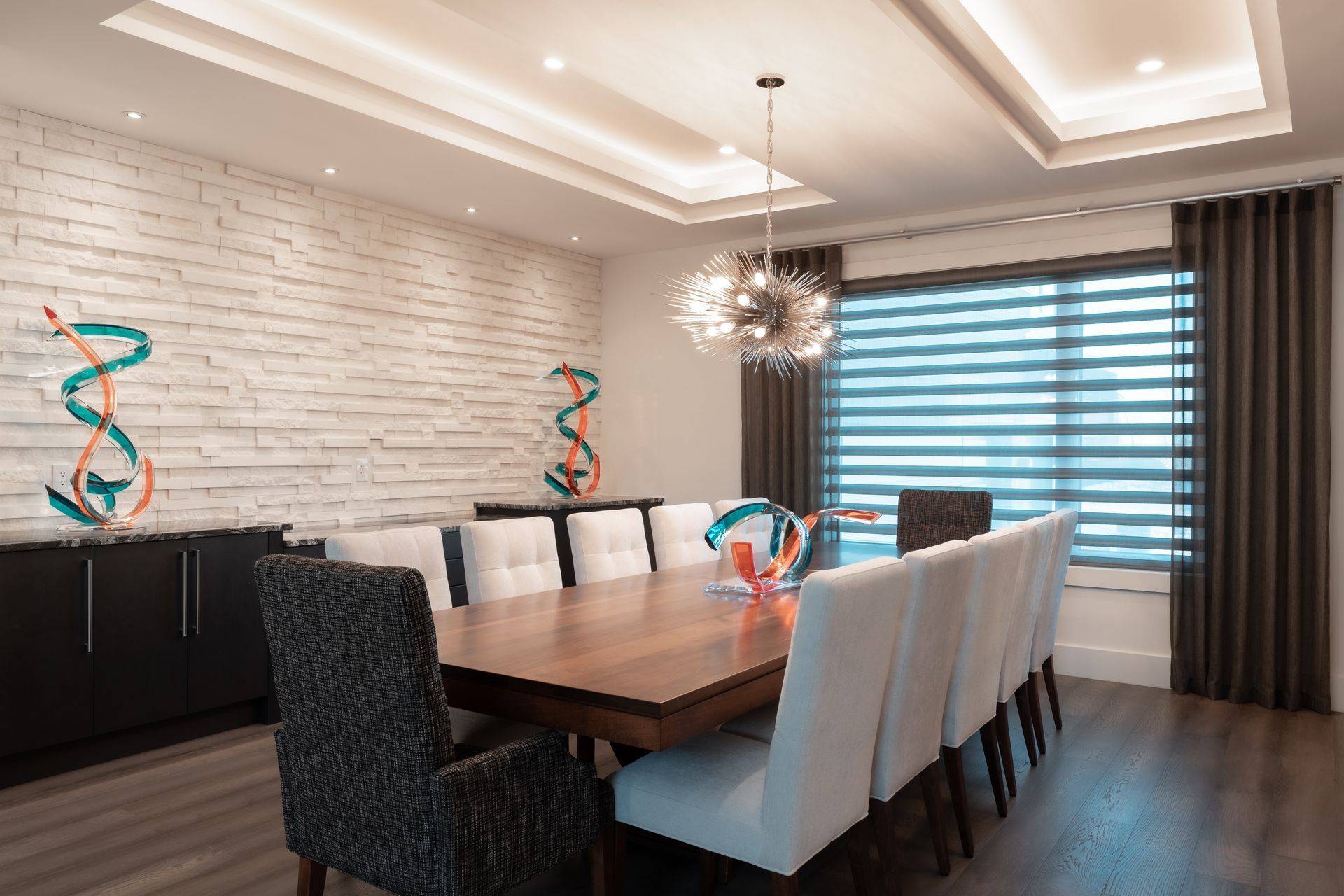 A dining room with a long table and chairs and a chandelier.