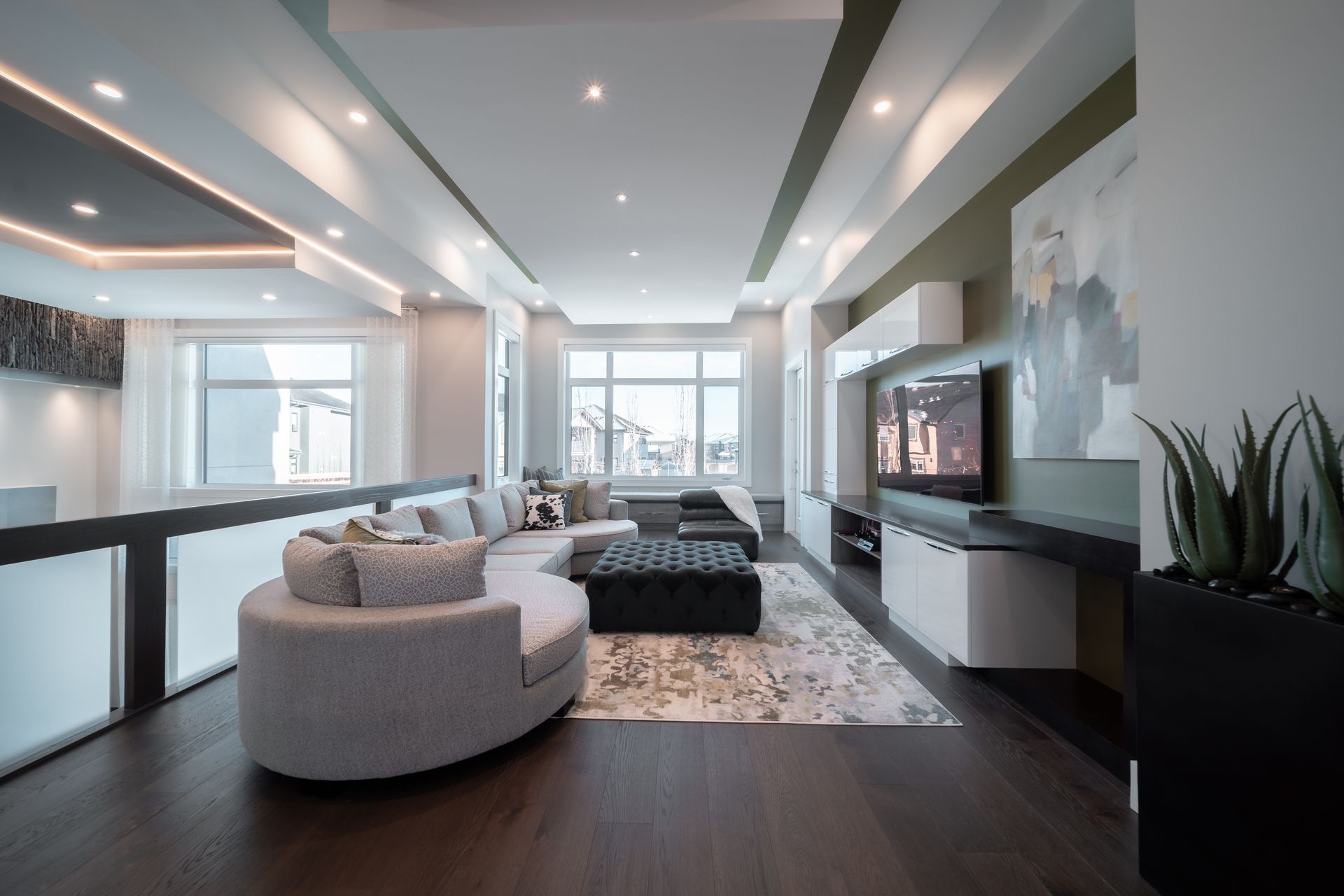 A living room with a round couch and a flat screen tv