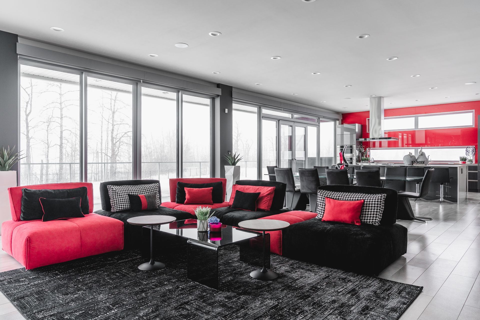 A living room with red and black furniture and a rug.