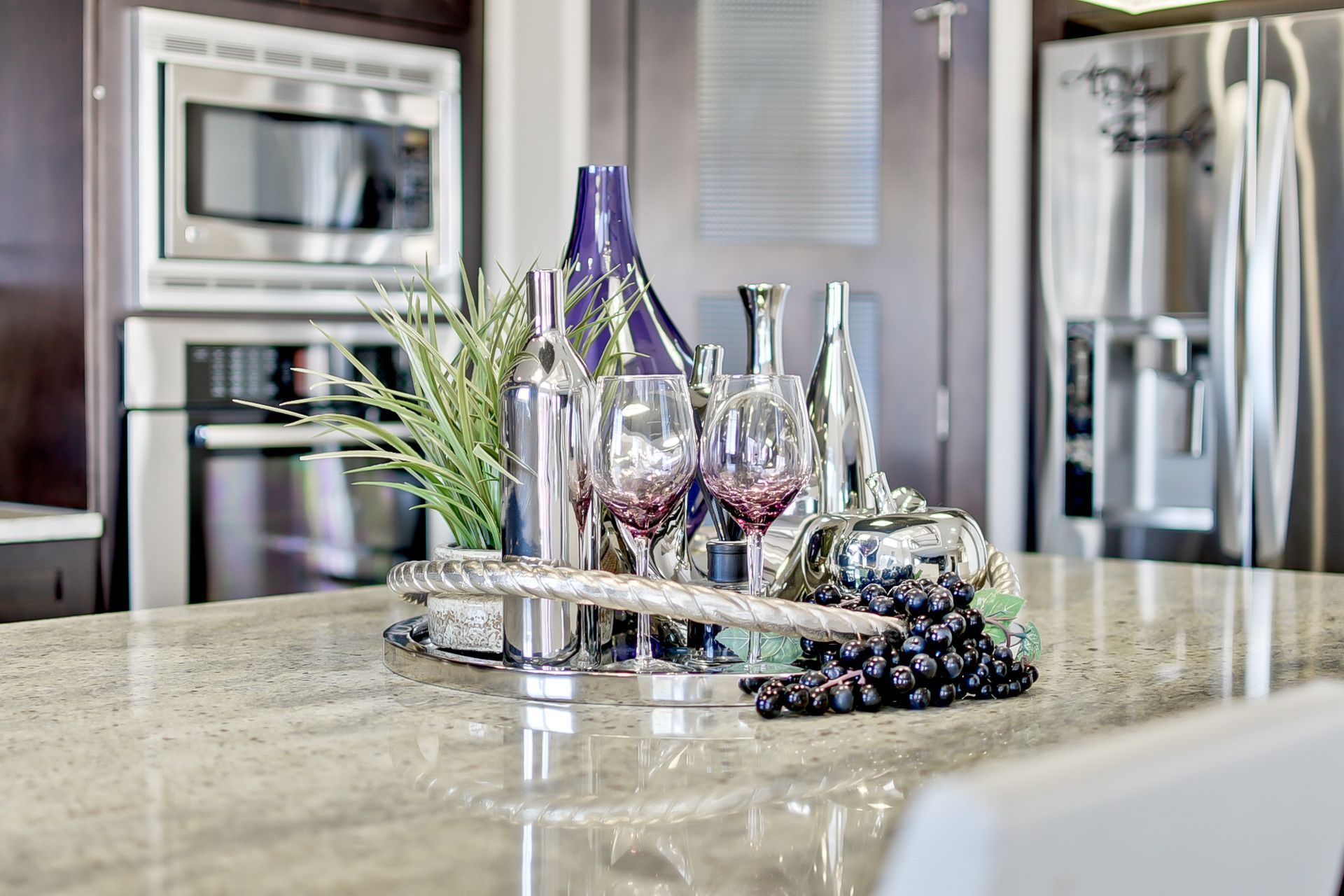 A kitchen counter with a tray of wine glasses and bottles on it.
