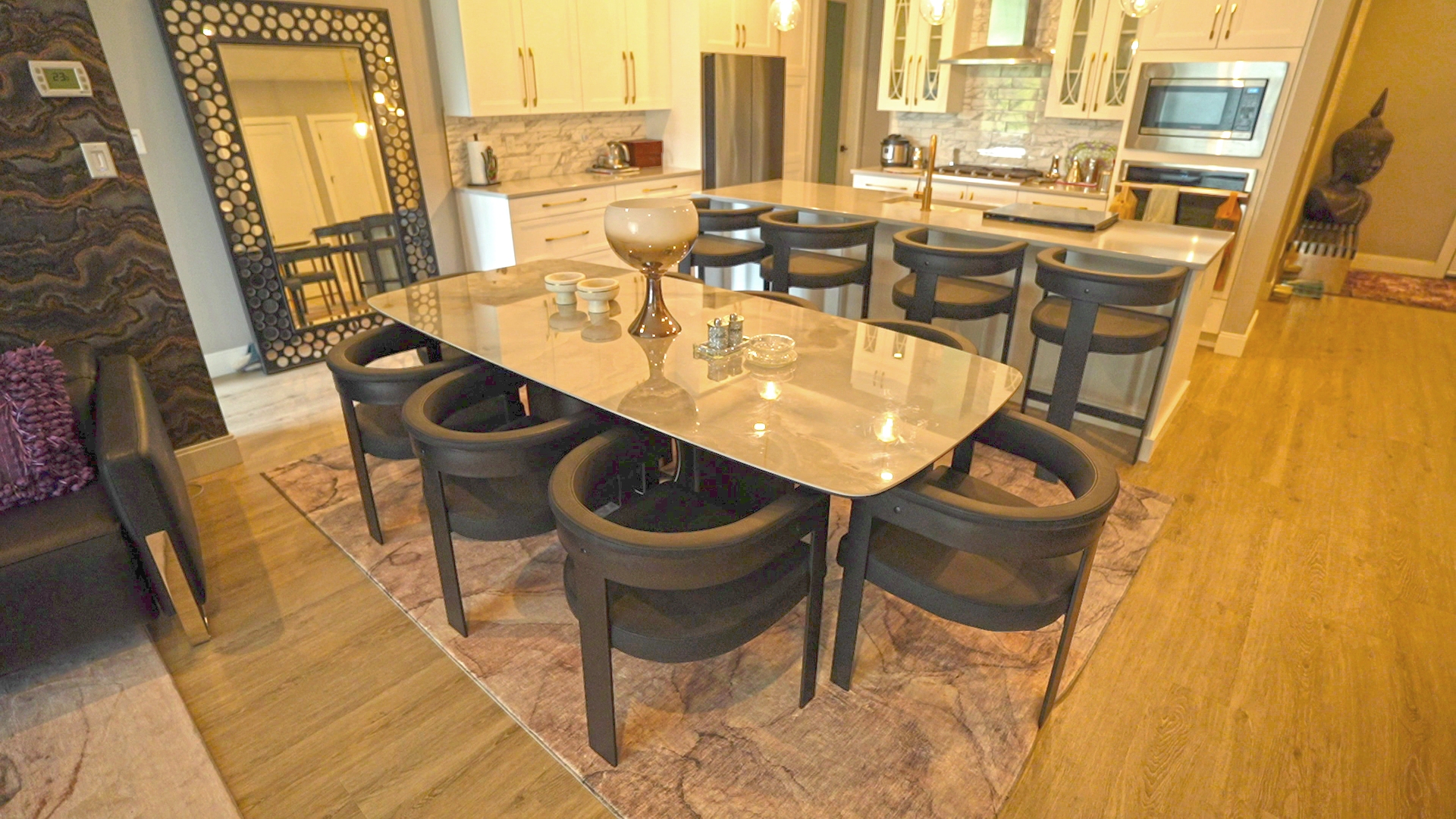 A dining room table with chairs and a large mirror in a kitchen.