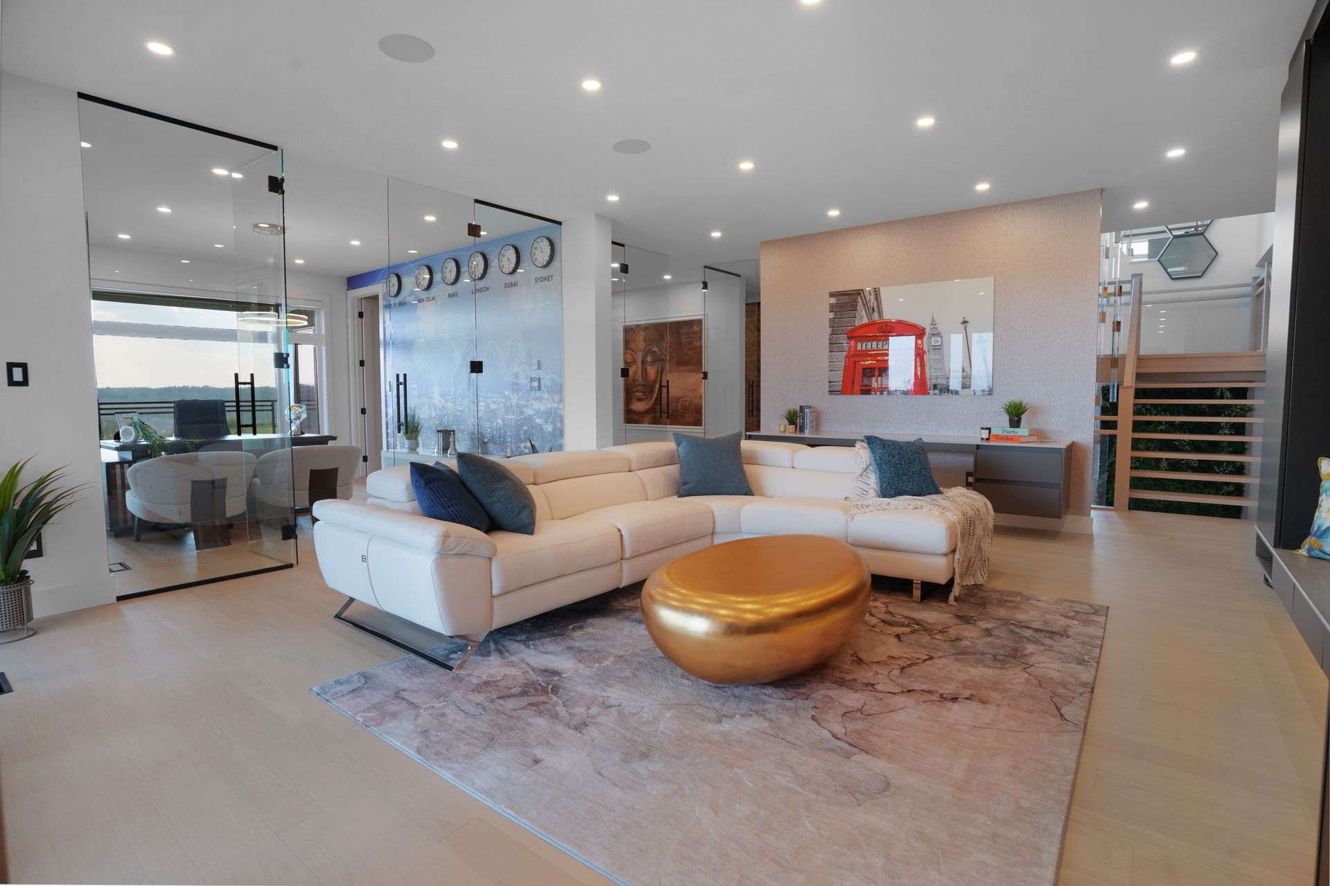 A living room with a white sectional couch and a gold coffee table.