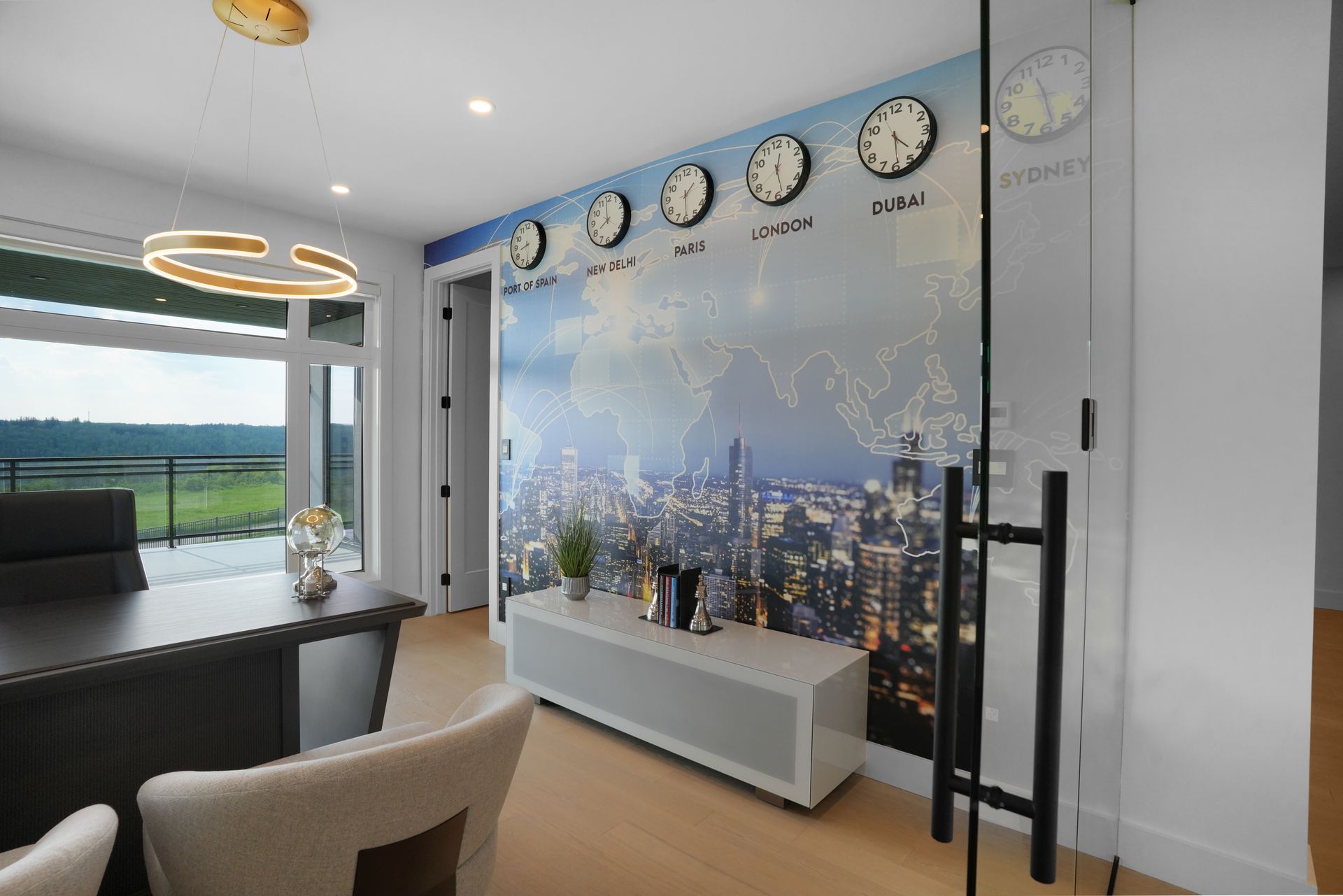 A room with clocks on the wall and a picture of a city on the wall.