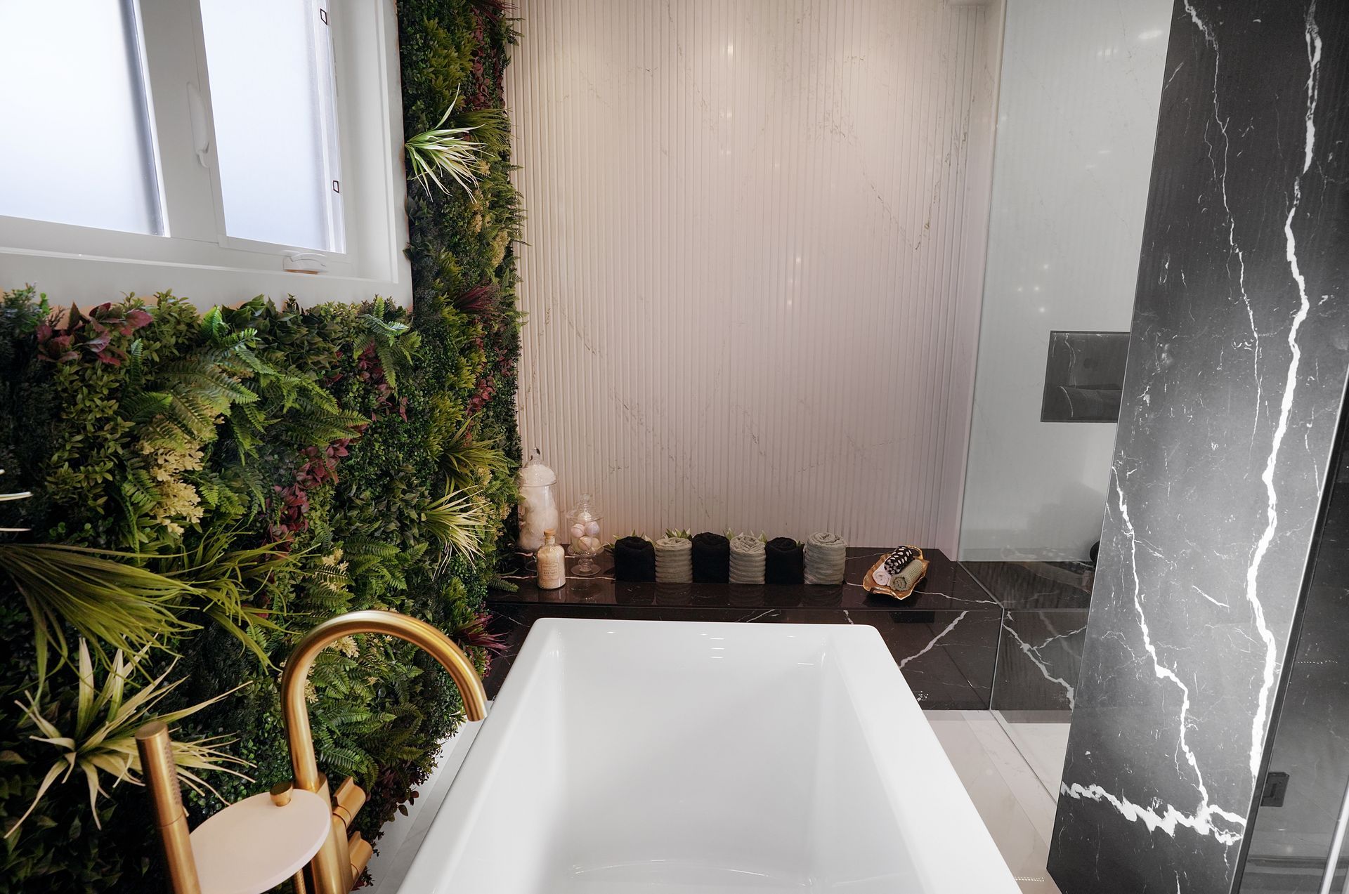A bathroom with a bathtub and a green wall.