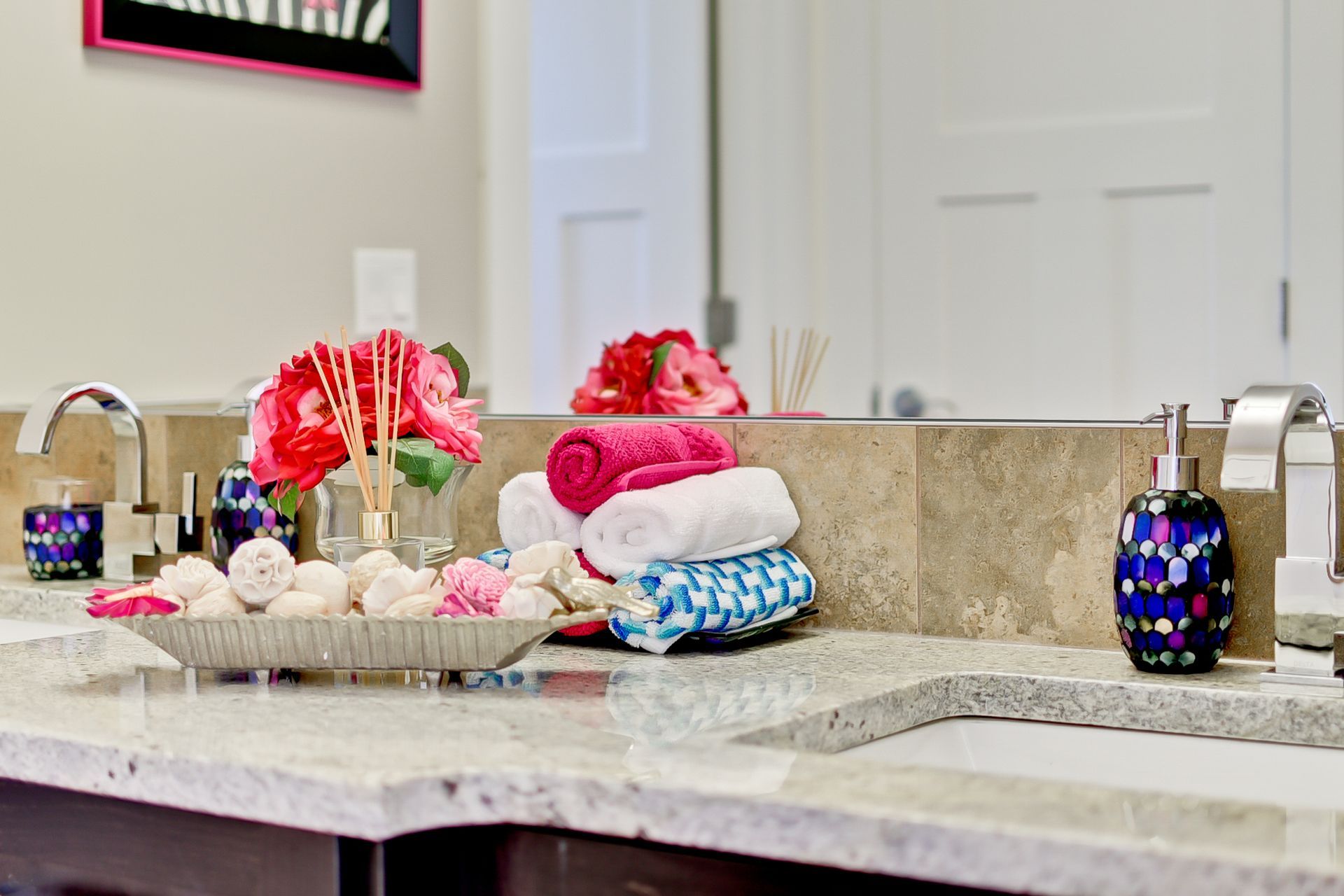 A bathroom sink with a stack of towels on it.