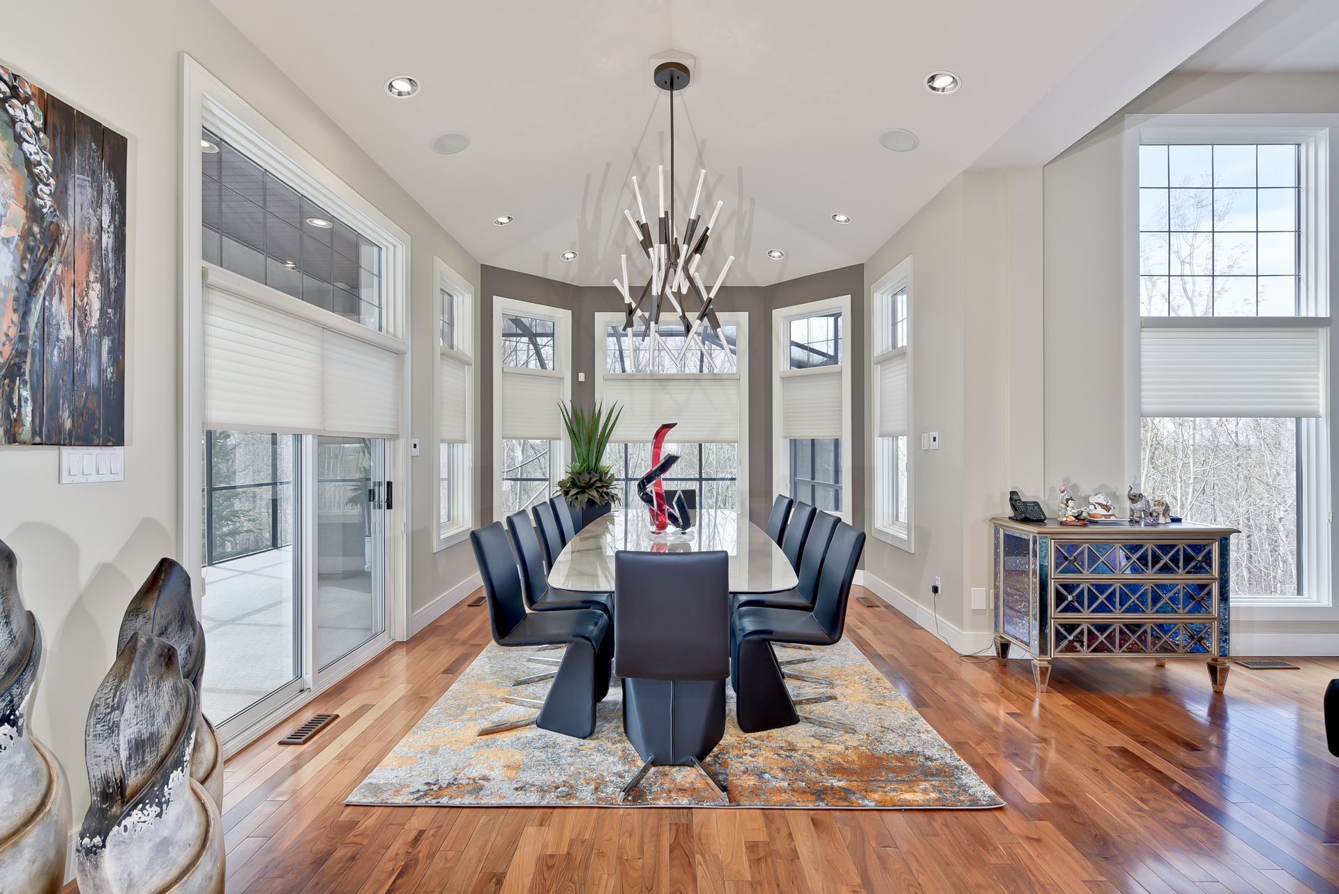 A large dining room with a long table and chairs and a chandelier.