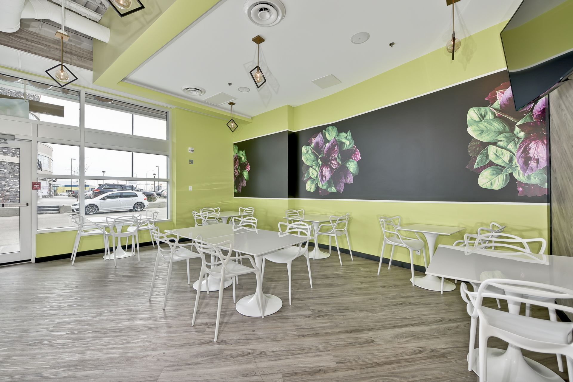 A restaurant with tables and chairs and a large mural on the wall.