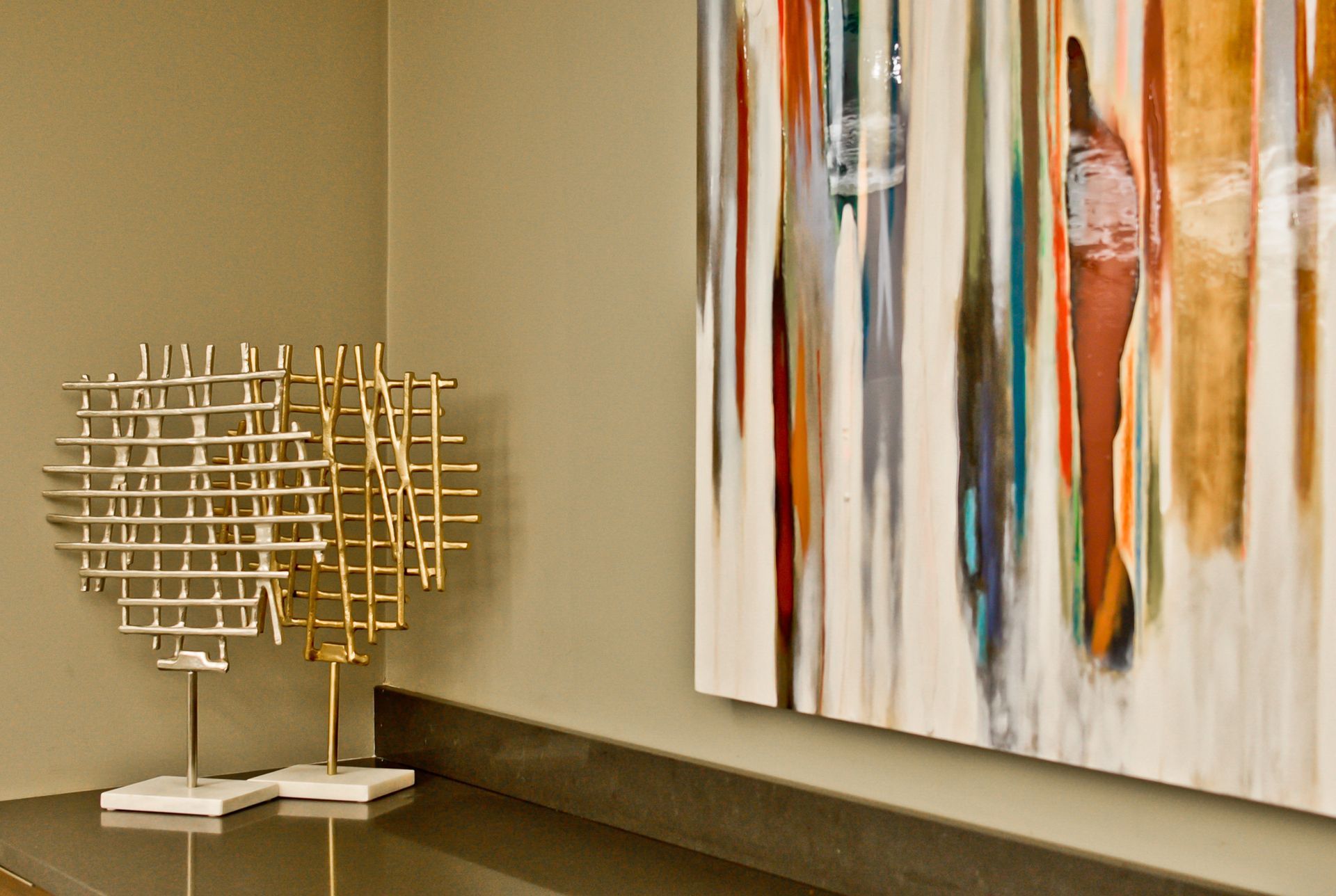 A painting is hanging on a wall next to a heart shaped sculpture