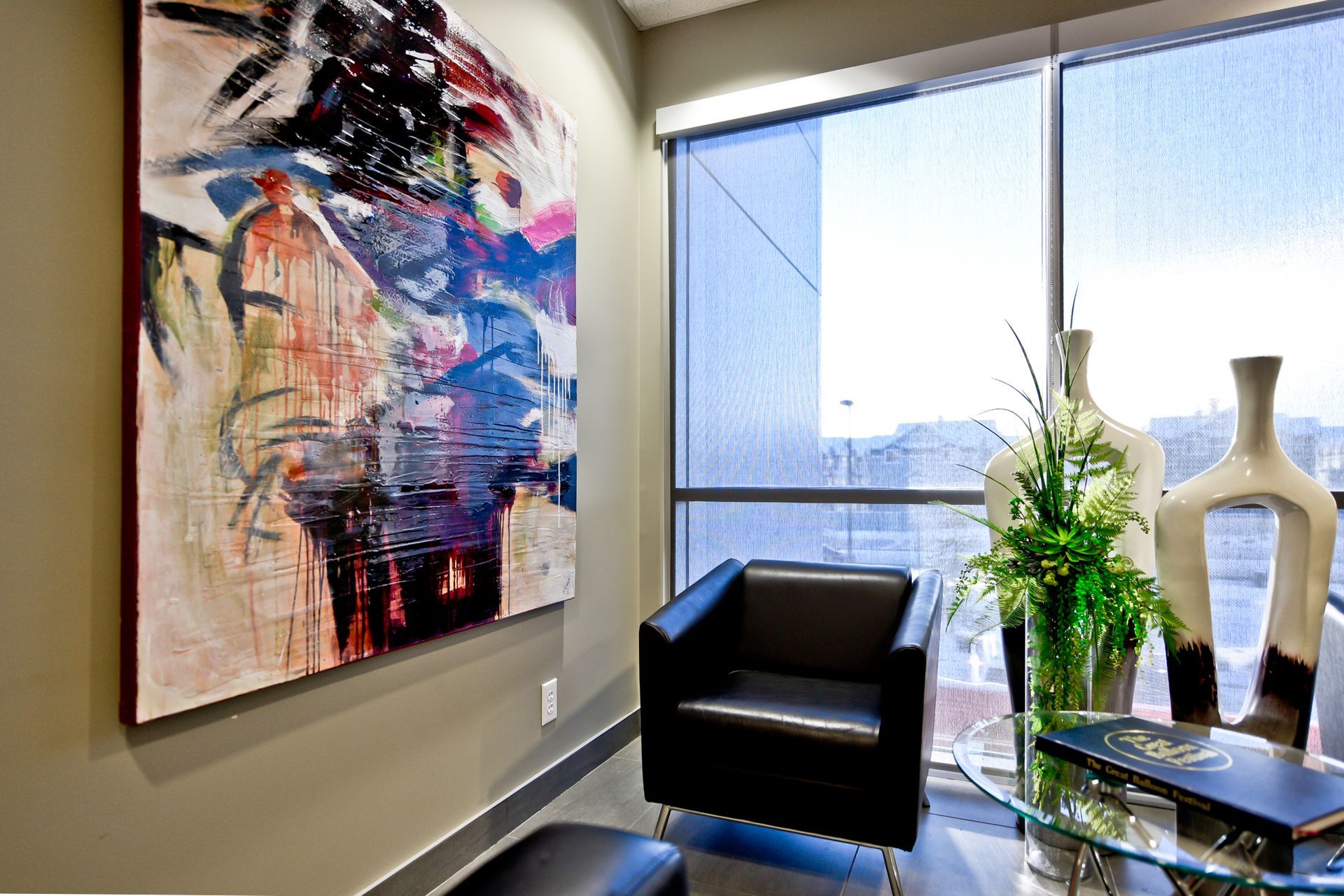 A living room with a chair and a painting on the wall