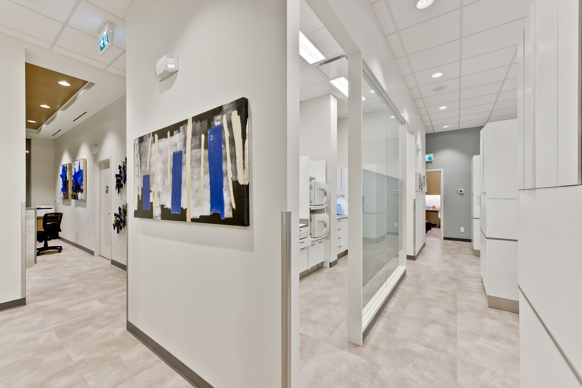 A hallway in a dental office with a painting on the wall.