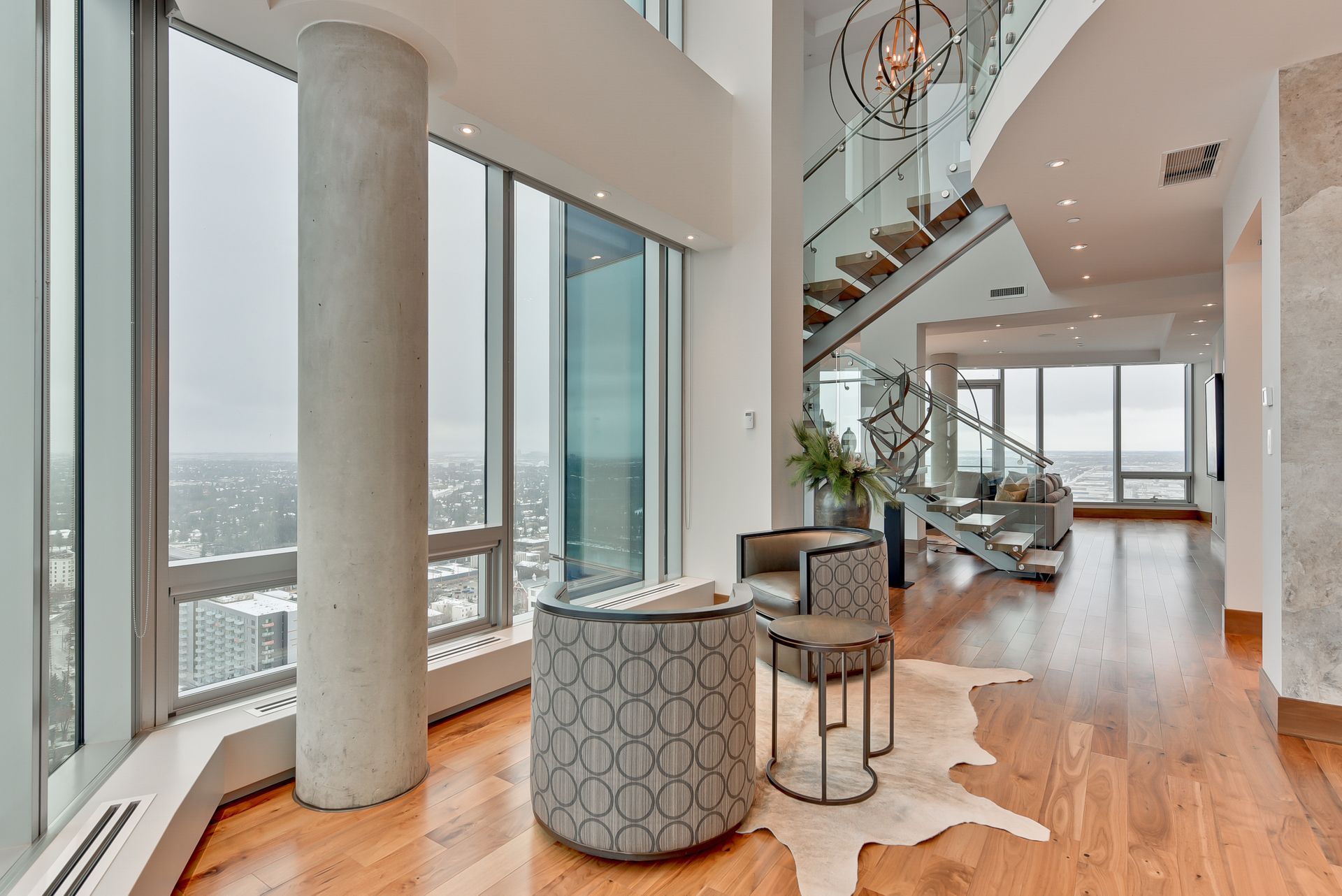 A living room with a lot of windows and a staircase