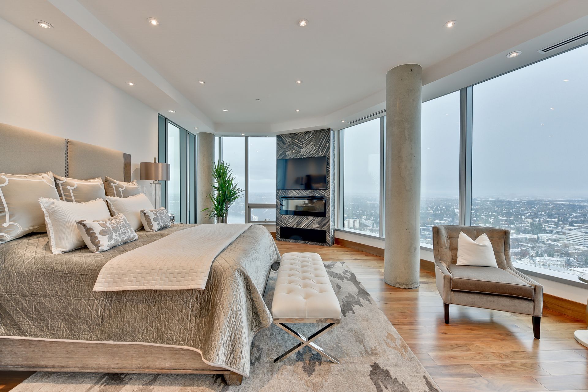 There is a large bed in the middle of the room with a lot of windows.