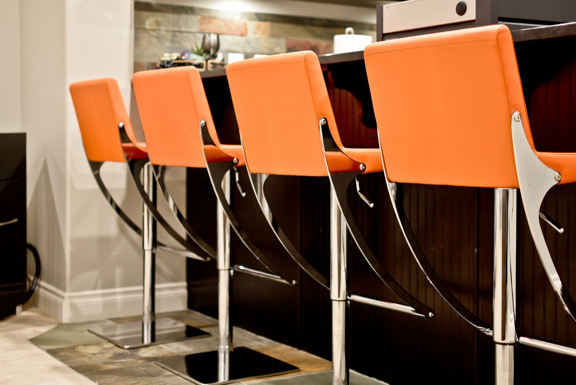 A row of orange bar stools in a kitchen